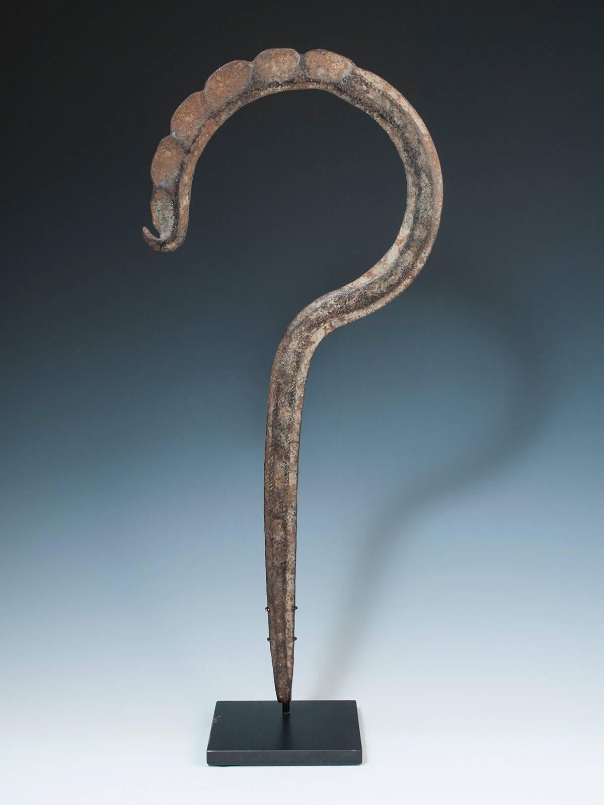 Rare late 19th century Tribal forged iron Hook Currency, Cameroon/ NE Nigeria, upper Banue River area

A graceful forged iron currency piece shaped like a question mark or a fiddle head fern; comes with a custom base.