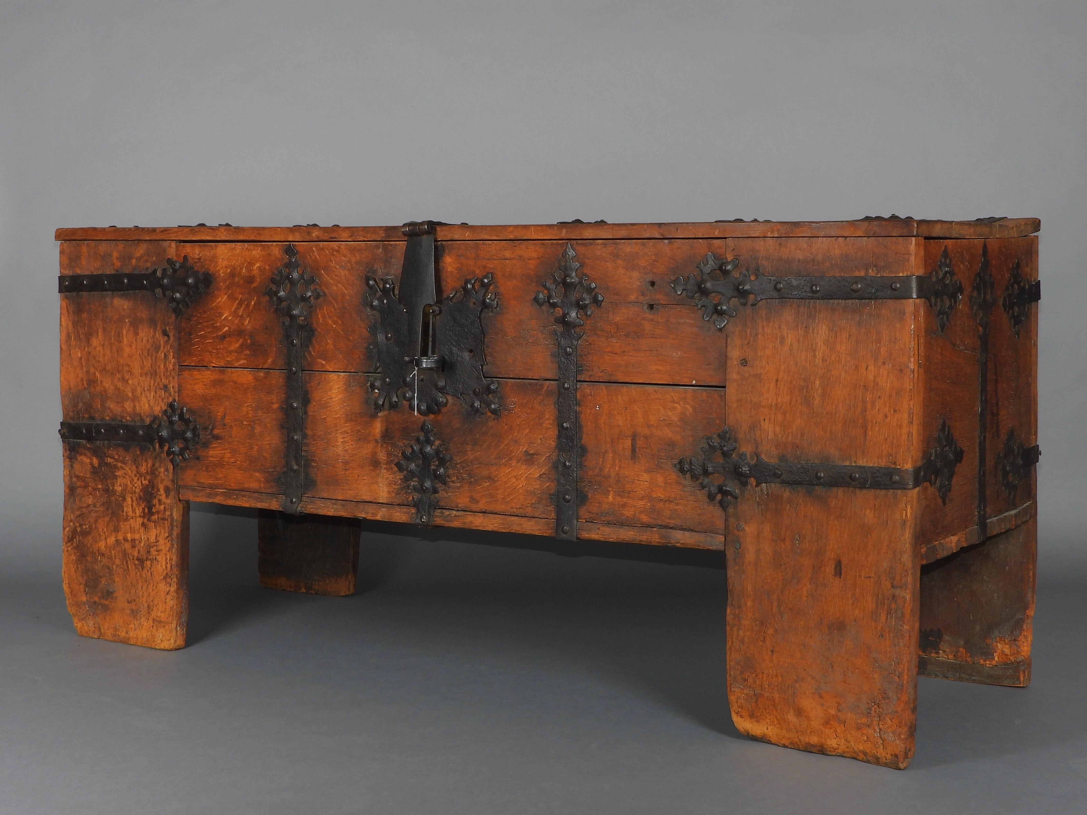 A very impressive Westphalian Gothic chest or ‚Stollentruhe’, Westphalia, Germany, circa 1500-1550. Wrought iron mounted oak, partially carved. The monumental rectangular standing chest with full-height stiles, extensively mounted with wrought