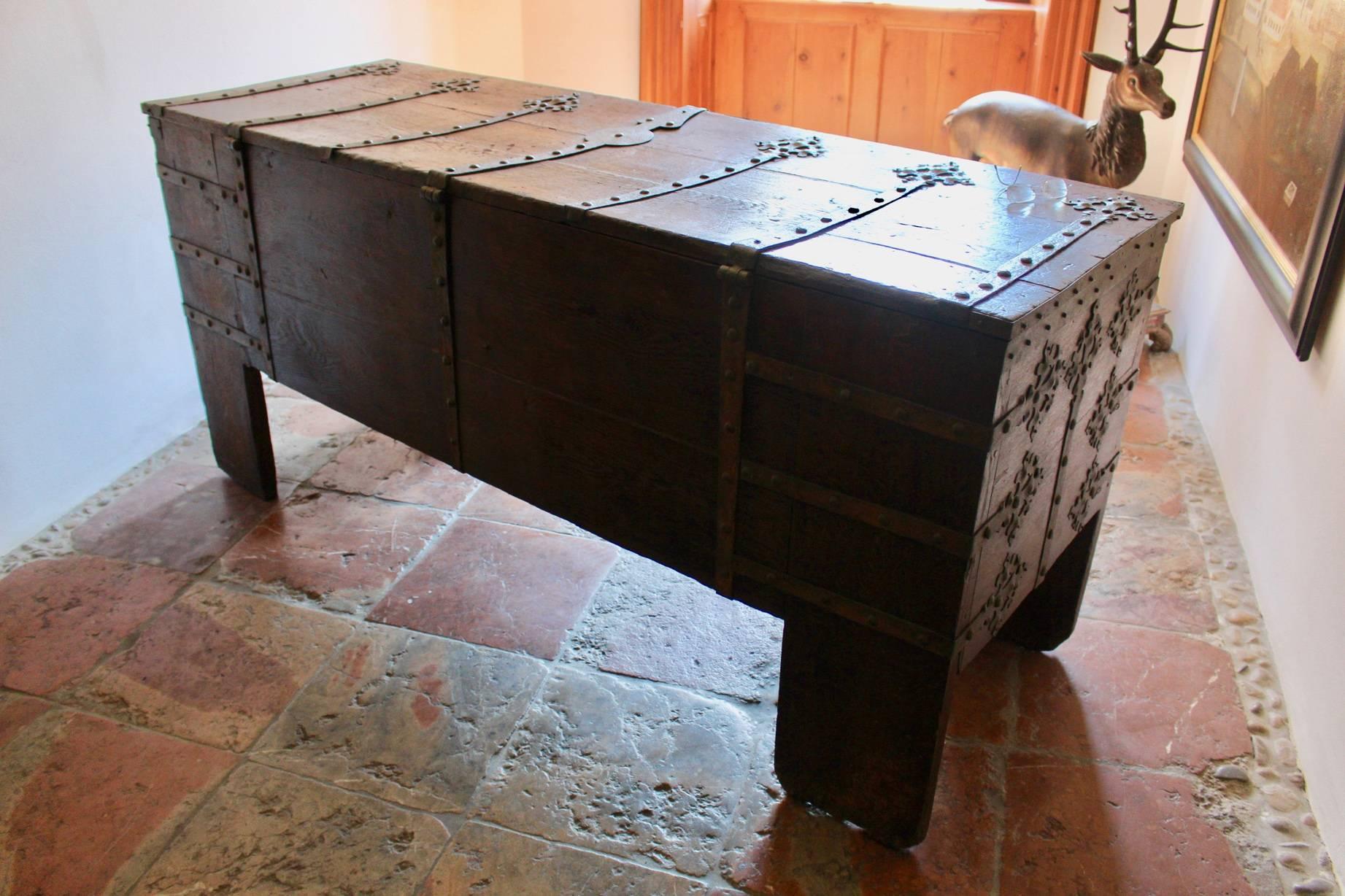 A very impressive Westphalian Gothic chest or ‚Stollentruhe’, Westphalia, Germany, circa 1500-1550. Wrought iron mounted oak, partially carved. The monumental rectangular standing chest with full-height stiles, extensively mounted with wrought