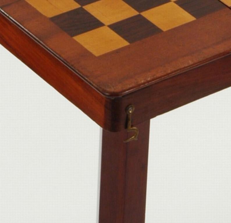 With telescopic columns and tripod legs, which dismantle to fit into the folding top to form a traveling box. Constructed of mahogany throughout the games board is inlaid with Goncalo Alves and boxwood veneers. A rare model.
