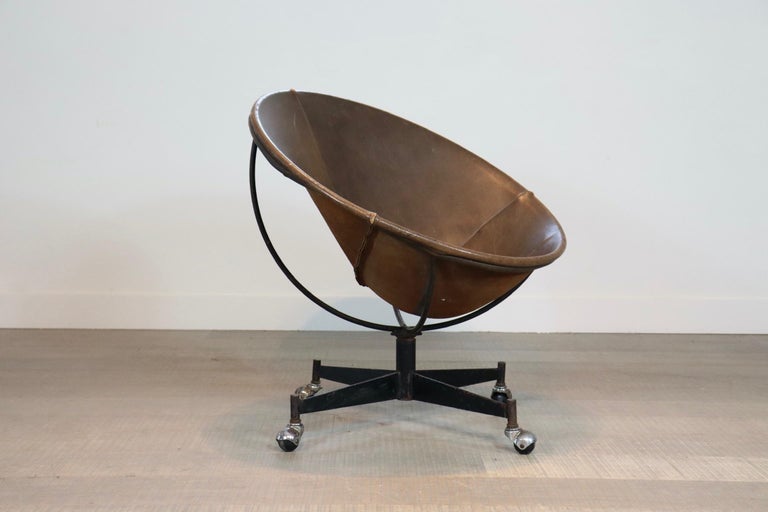 An exceptionally rare bucket chair with its original steel weels, designed by renowned designer and former Pratt professor, William Katavolos. This example was produced in the early 1970s and remains an original example. It retains its original