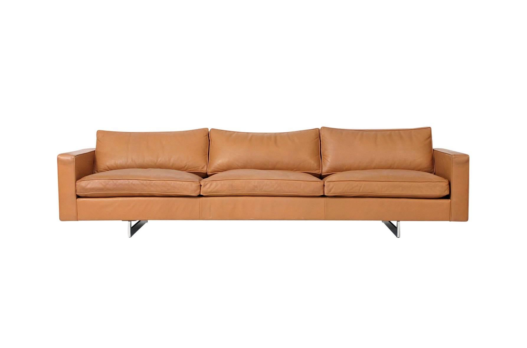 Rare sofa and chair set by noted American designer Jens Risom. Large-scale and comfortable seating in original tan leather with down filled cushions over chrome steel sled bases. Priced as a set please inquire for individual pricing. Chair