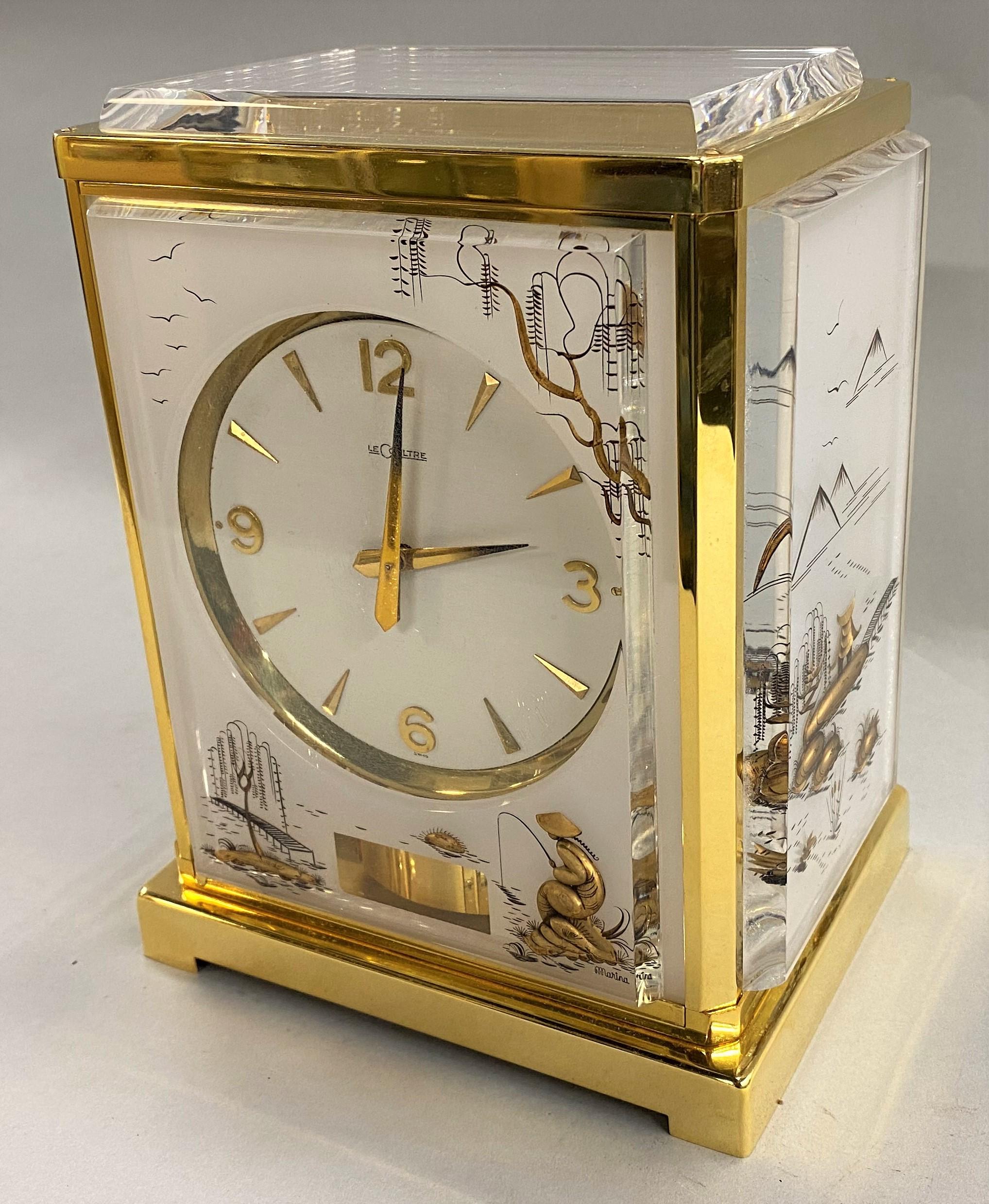 A fine Jaeger-LeCoultre white Marina Atmos perpetual motion clock with an oriental design. The clock has mounted stylized lucite panels with oriental or Asian design, its movement wound by barometric pressure. The front panel has an aperture to view