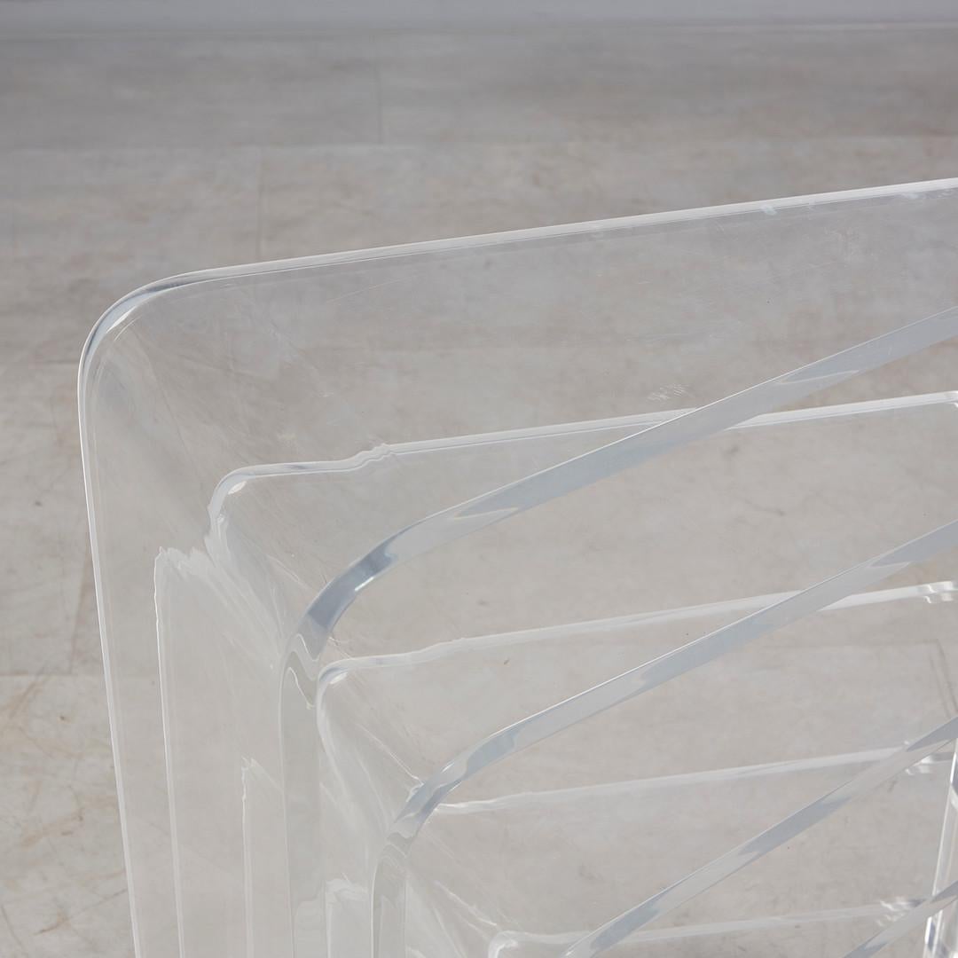 Construcción libremente ajustable con mesas nido dispuestas cocéntricamente de varias alturas y tamaños, de cristal acrílico. Ligeros signos de envejecimiento y desgaste.