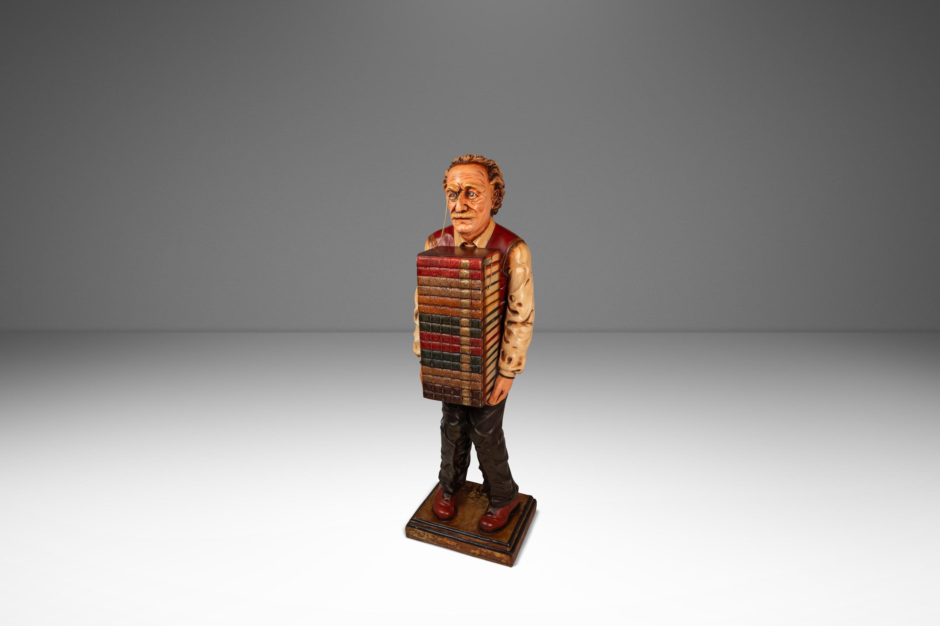 Introducing a rare, hand-made sculpture depicting the iconic theoretical physicist Albert Einstein carrying a large stack of books. The book stack is actually a hidden wooden storage cabinet with three fixed shelves accessed by a hinged door. One