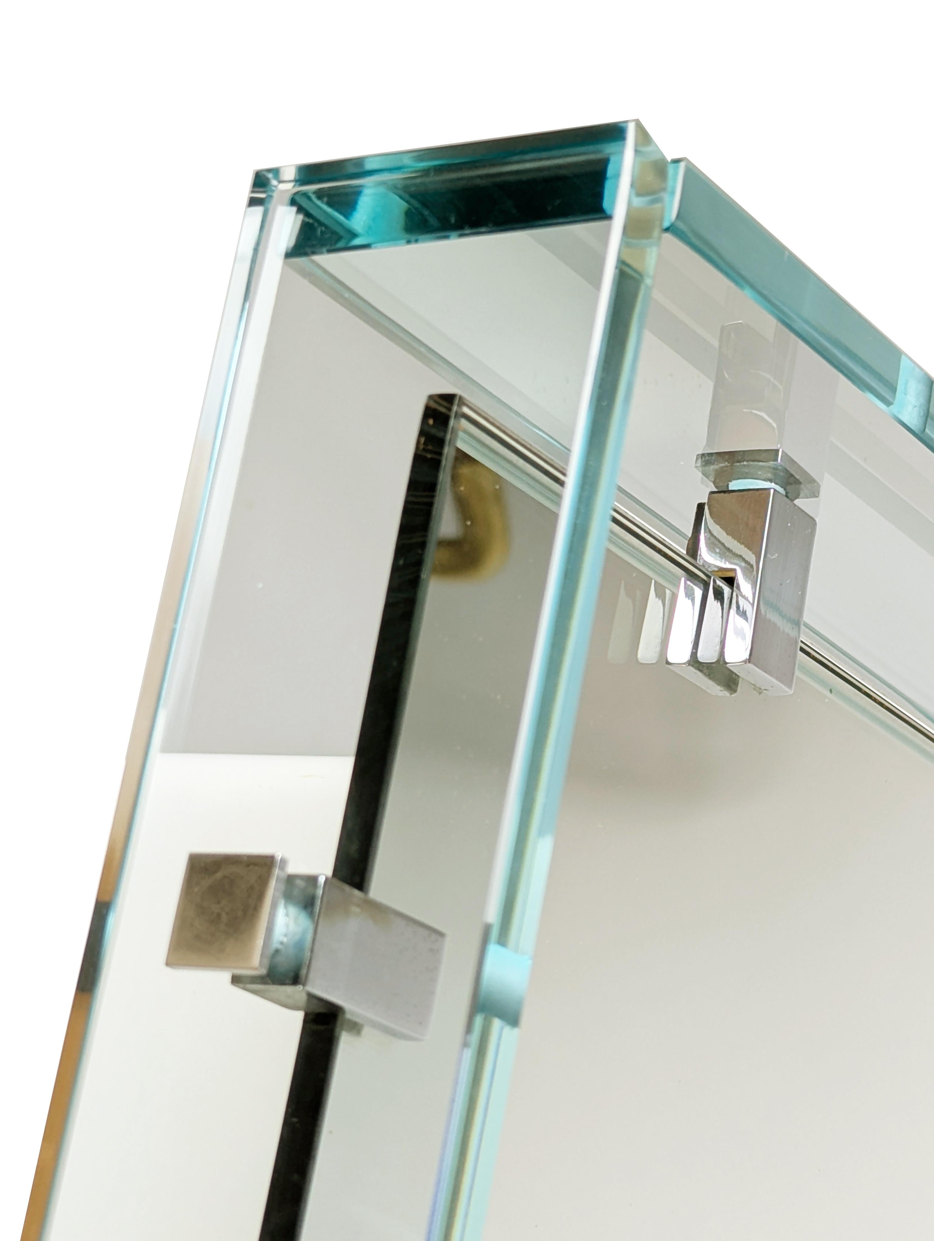 Rare et magnifique miroir mural rectangulaire MOD. 2014 en feuilles de verre taillées azur, métal chromé et verre miroité. Les 4 éléments en verre qui composent le cadre sont reliés au corps principal par 4 supports en métal chromé. Très bon état
