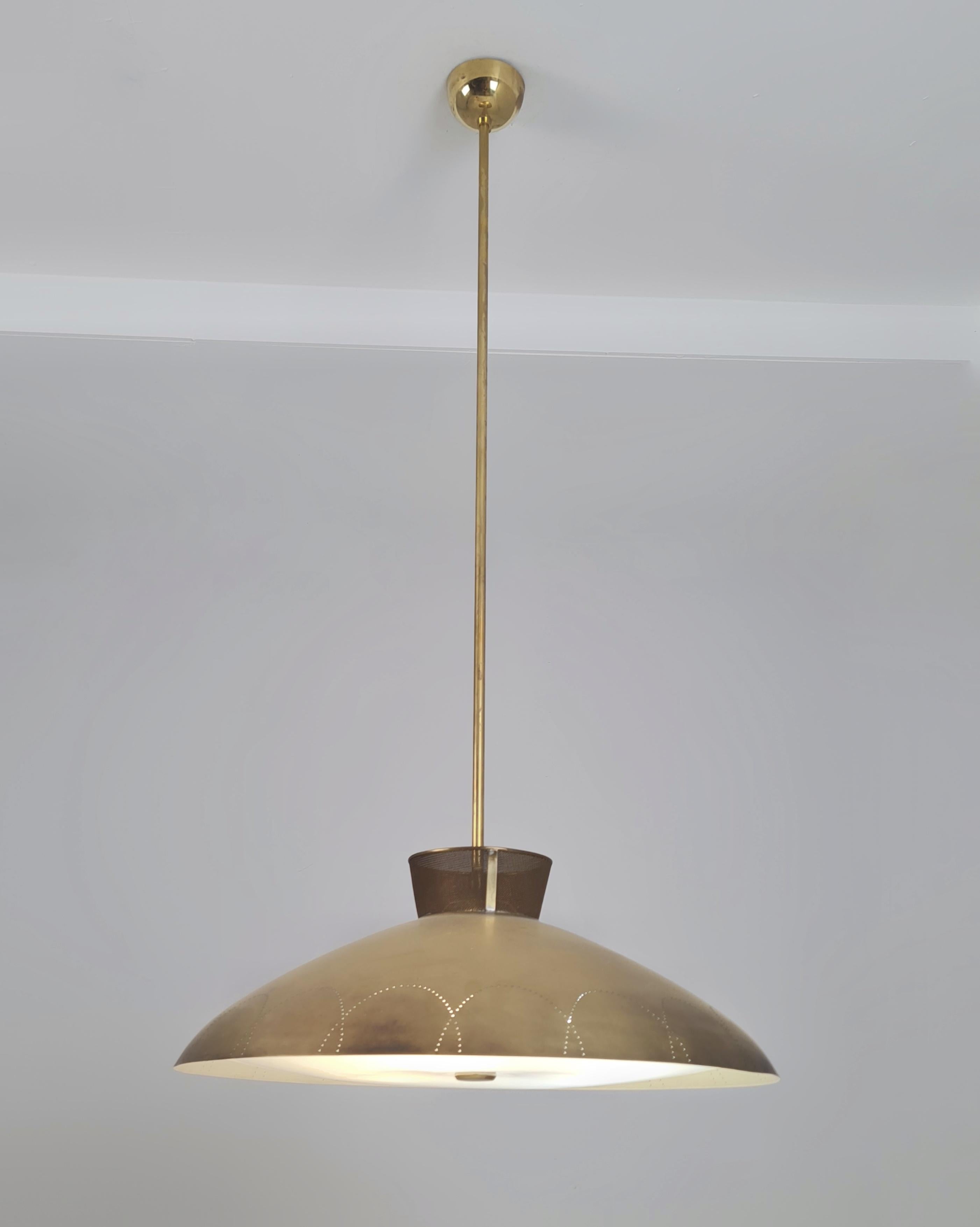 Una rara lampada da soffitto in ottone Lisa Johansson-Pape, prodotta da Orno Oy in Finlandia negli anni Cinquanta. Un design bellissimo con un paralume in ottone che presenta perforazioni distintive che fanno risaltare la lampada quando viene