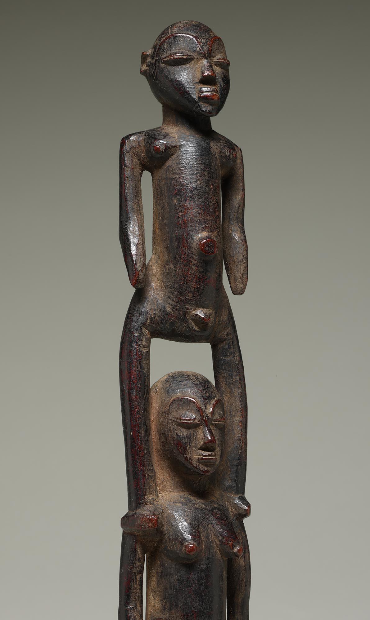 Rara figura doppia unita in piedi, con la figura maschile in cima che poggia sulle spalle della donna.  Patina profonda e usura da uso tradizionale. Volti finemente scolpiti ed espressivi.

Altezza 11 1/4 pollici su base metallica personalizzata