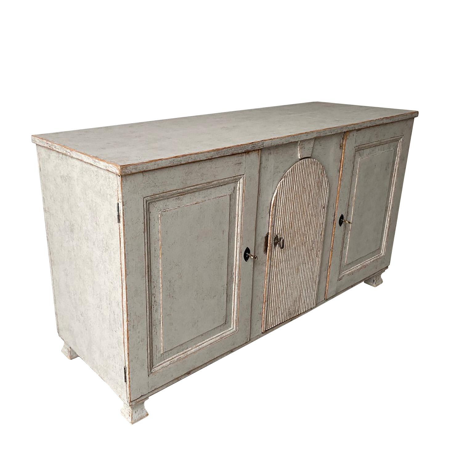 A long 18th century Swedish sideboard with three doors. This piece has been scraped to original paint inside and repainted a light grey on the outside.