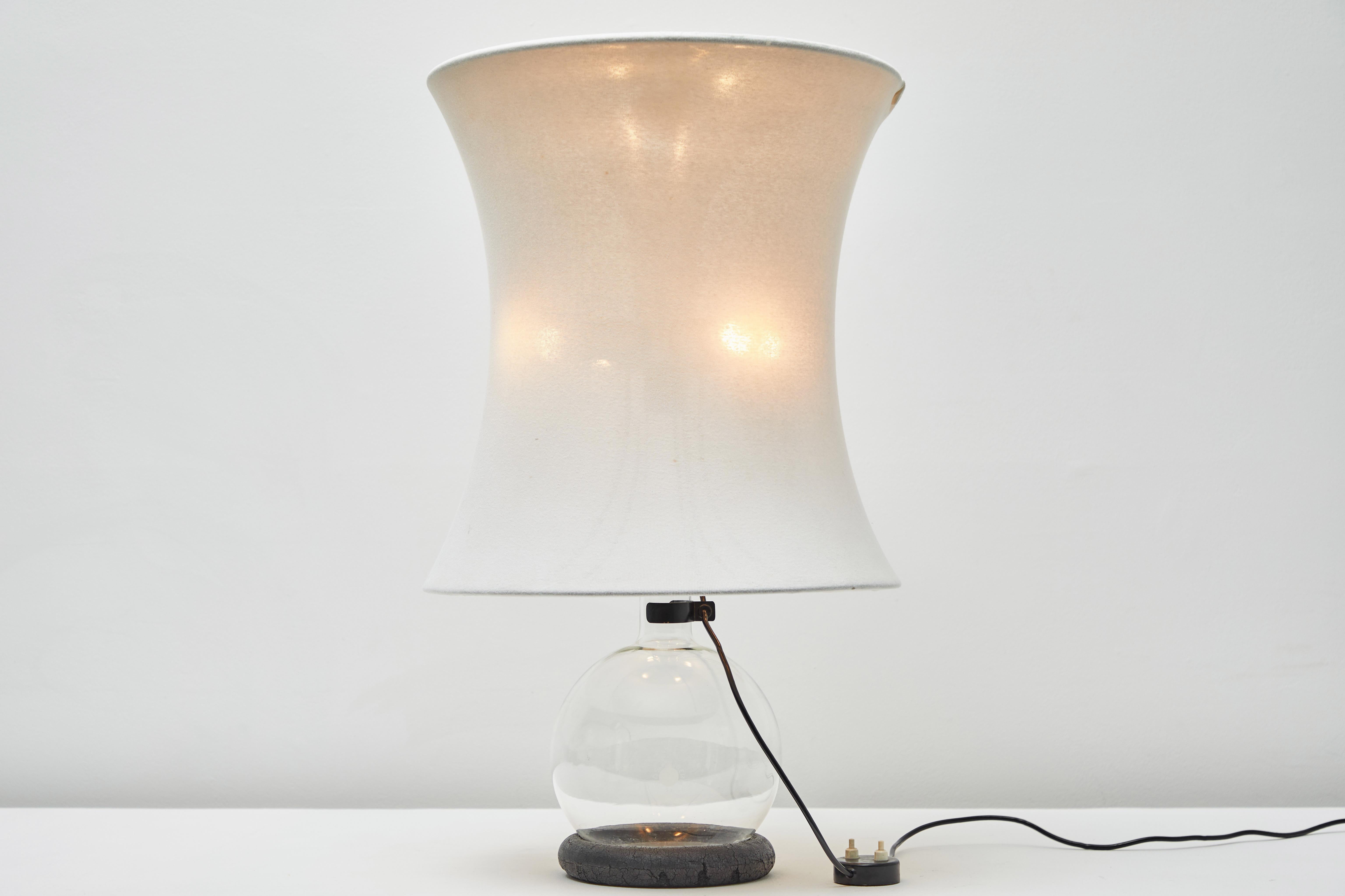 Rare lotus table lamp by Gianfranco Frattini for Meroni. Designed and manufactured in Italy, 1966. Wooden ring stand, glass base, metal armature covered in fabric. Shade is secured by an aluminum deflector at top of shade and secured to base by a