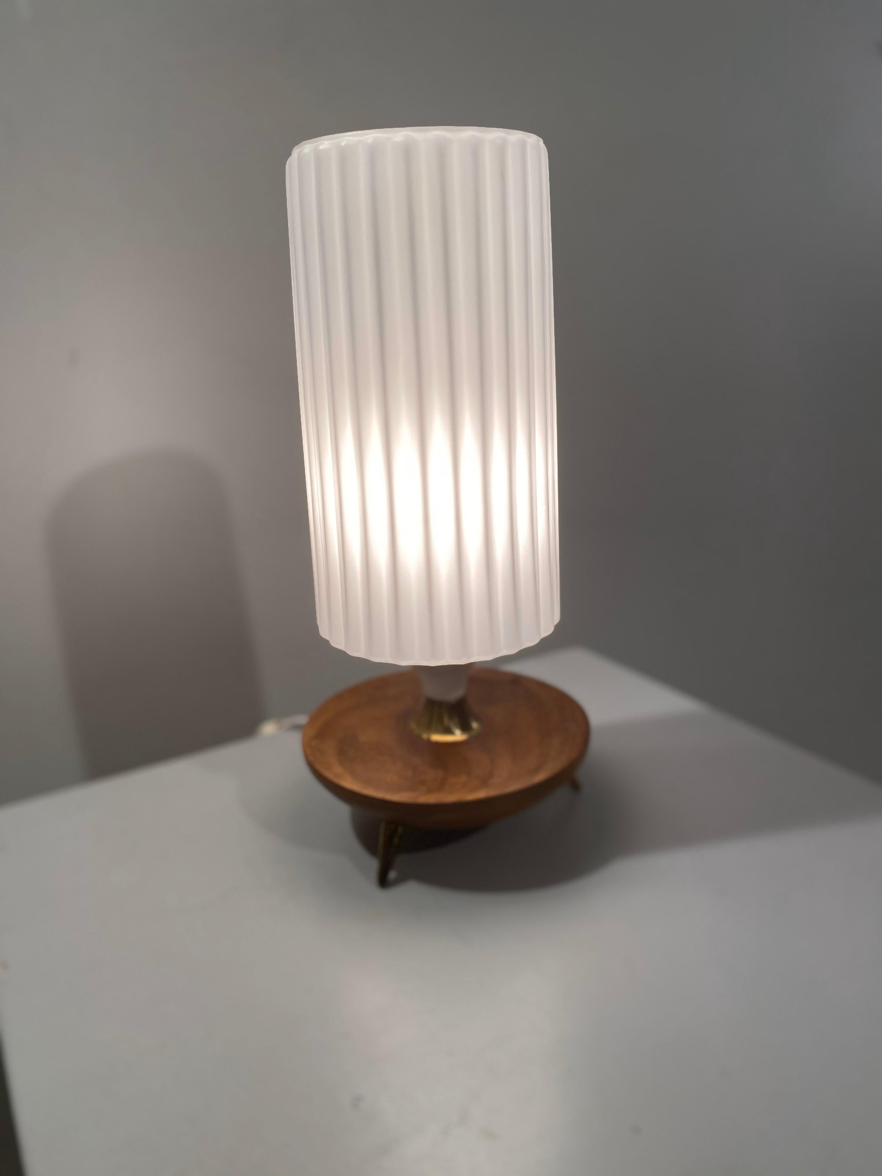 Beautiful rare desk lamp by Louis Kalff for Philips. A rugged milk glass shade fitted on a wood base with 3 copper legs and copper detailing.
