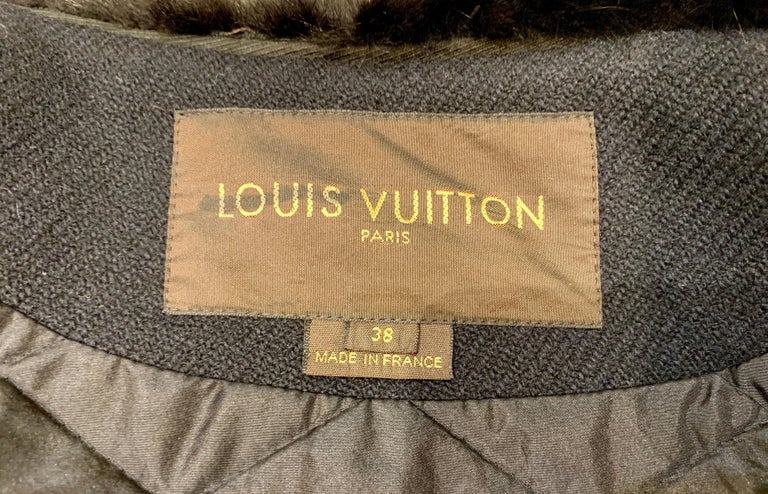 Elegant designer Louis Vuitton Paris ladies coat features a black wool exterior with a large, opulent black mink fur collar and soft rabbit fur lapel trim. The body of the coat is lined in quilted back polyamide, with black silk lined sleeves and