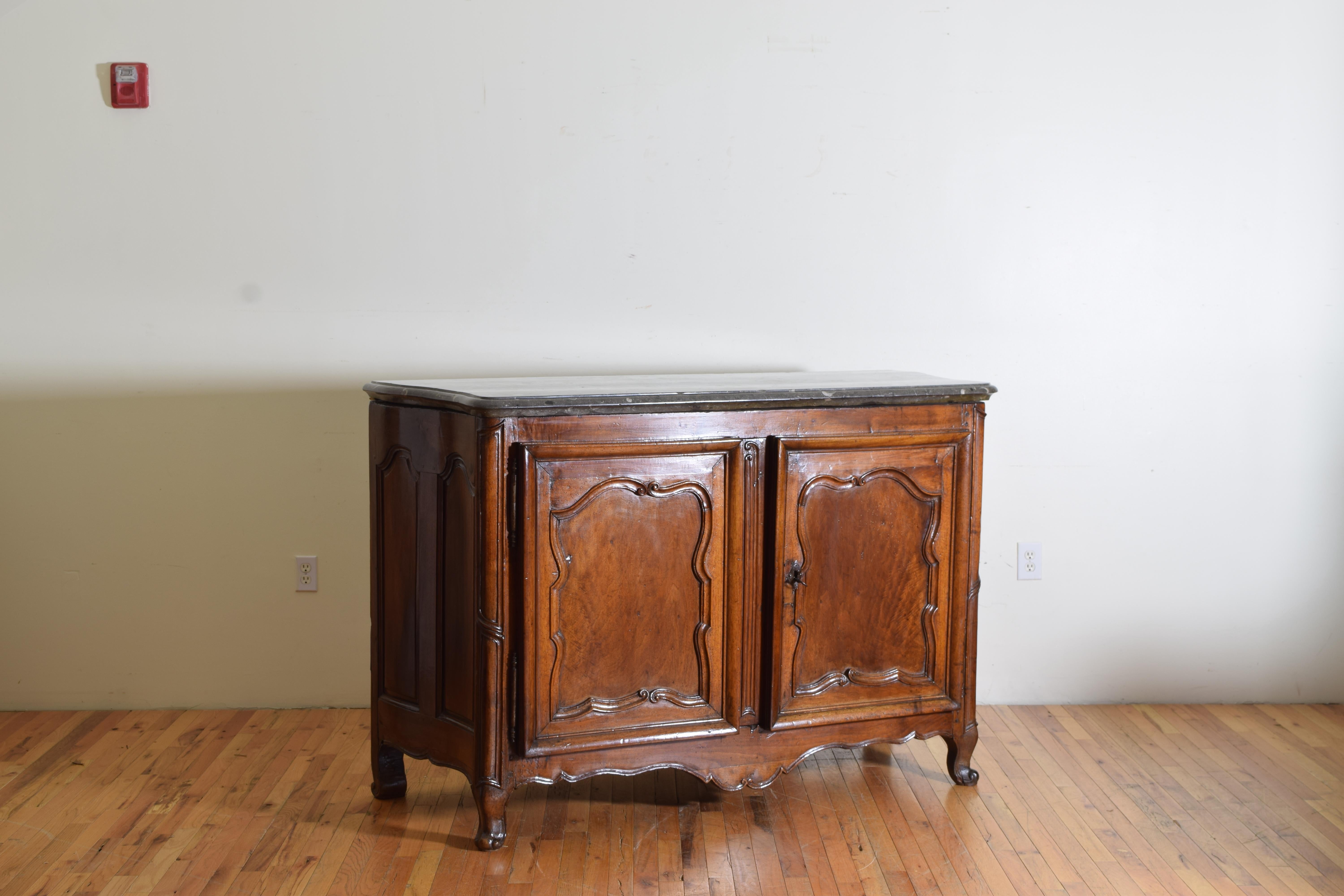 Rare Louis XIV/XV period carved walnut buffet, Marrone fossilized marble top having a thick shaped Maronne Fossil marble top atop a conforming case with stylized carved door panels and rounded corners with carved feet and apron, the interior and