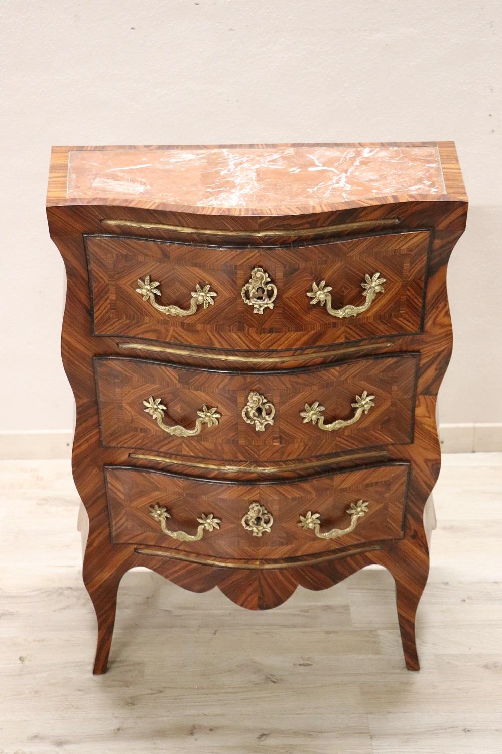 Rare and fine quality erly 20th century Italian Louis XV style antique small chest of drawers. On the front three comfortable drawers. Characterized by a particular wavy line on the front and sides with elegant saber legs. Fully decorated with