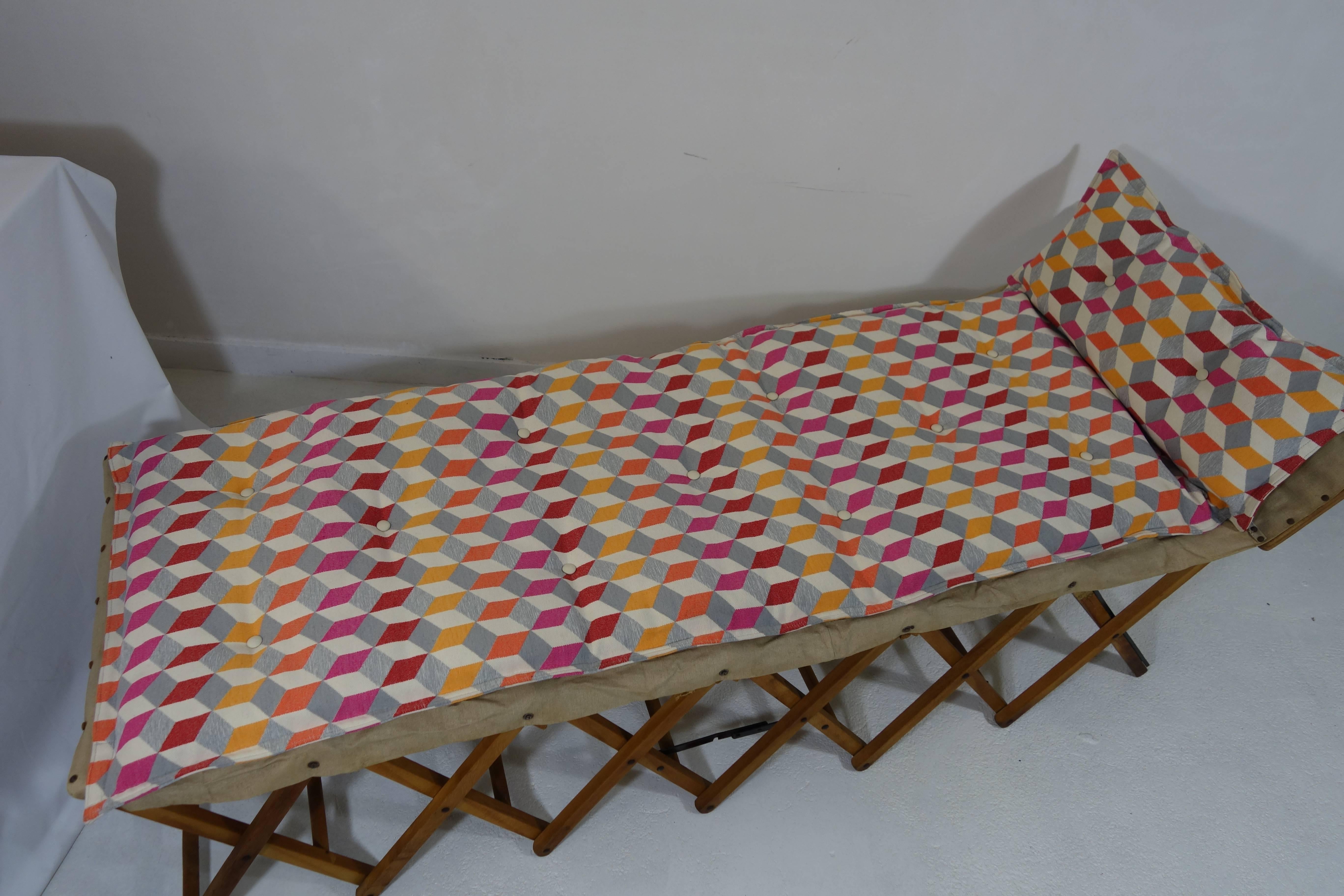 Beautiful foldable day bed made of wood and canvas. 
When folded it may serve as an occasional table. 
Its dimensions then are 55 cm high, 74 cm wide and 25 deep.
The cushion that comes with it is new. It was custom made to fit the shape of the