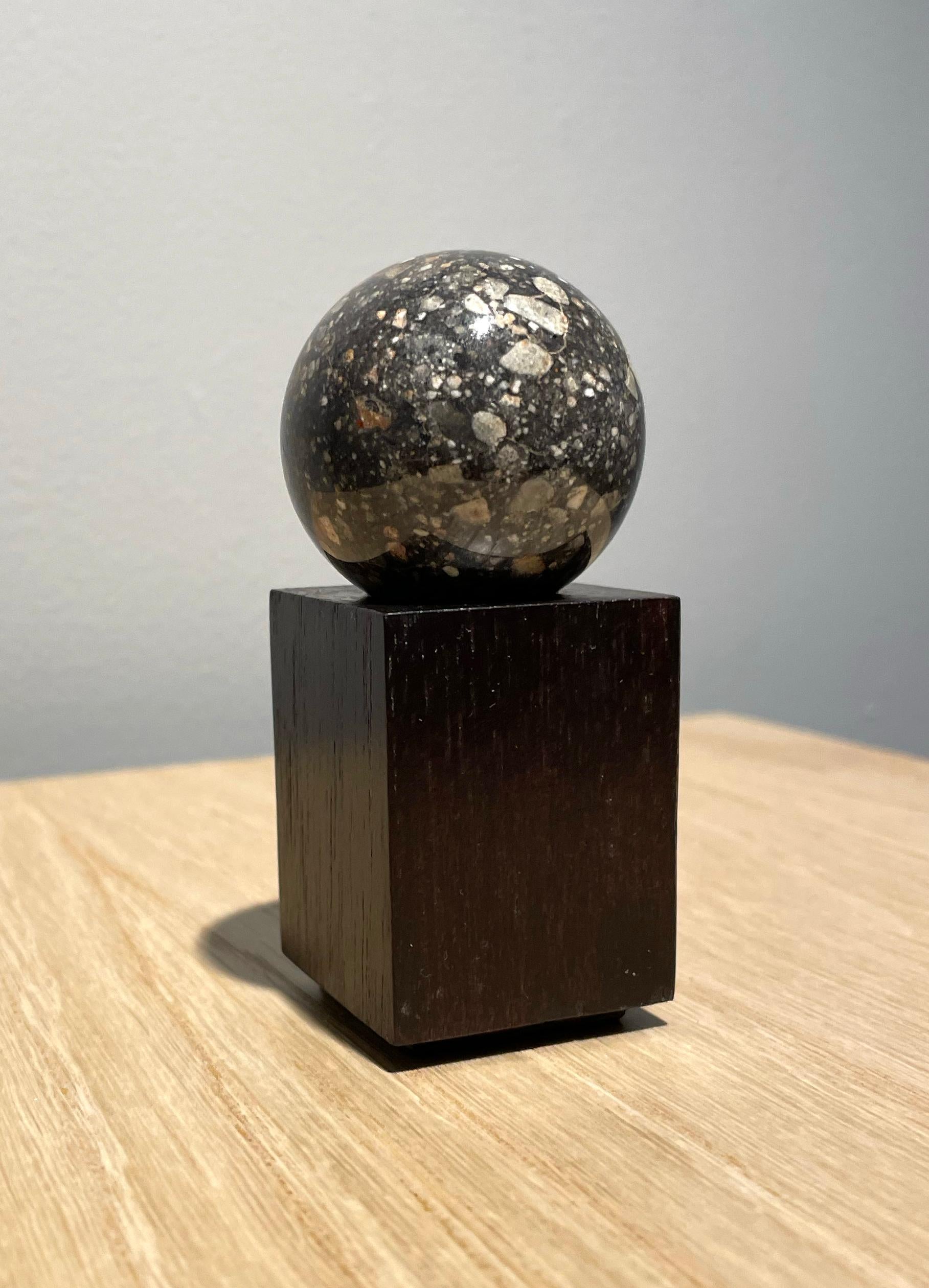 RARE LUNAR SPHERE
'Lunar feldspathic breccia'

Approximately 4.5 billion years ago 
4 cm diameter
Sahara Desert, Mauritania 

The moon is one of the rarest materials on earth. Every lunar meteorite known could be contained within just five
