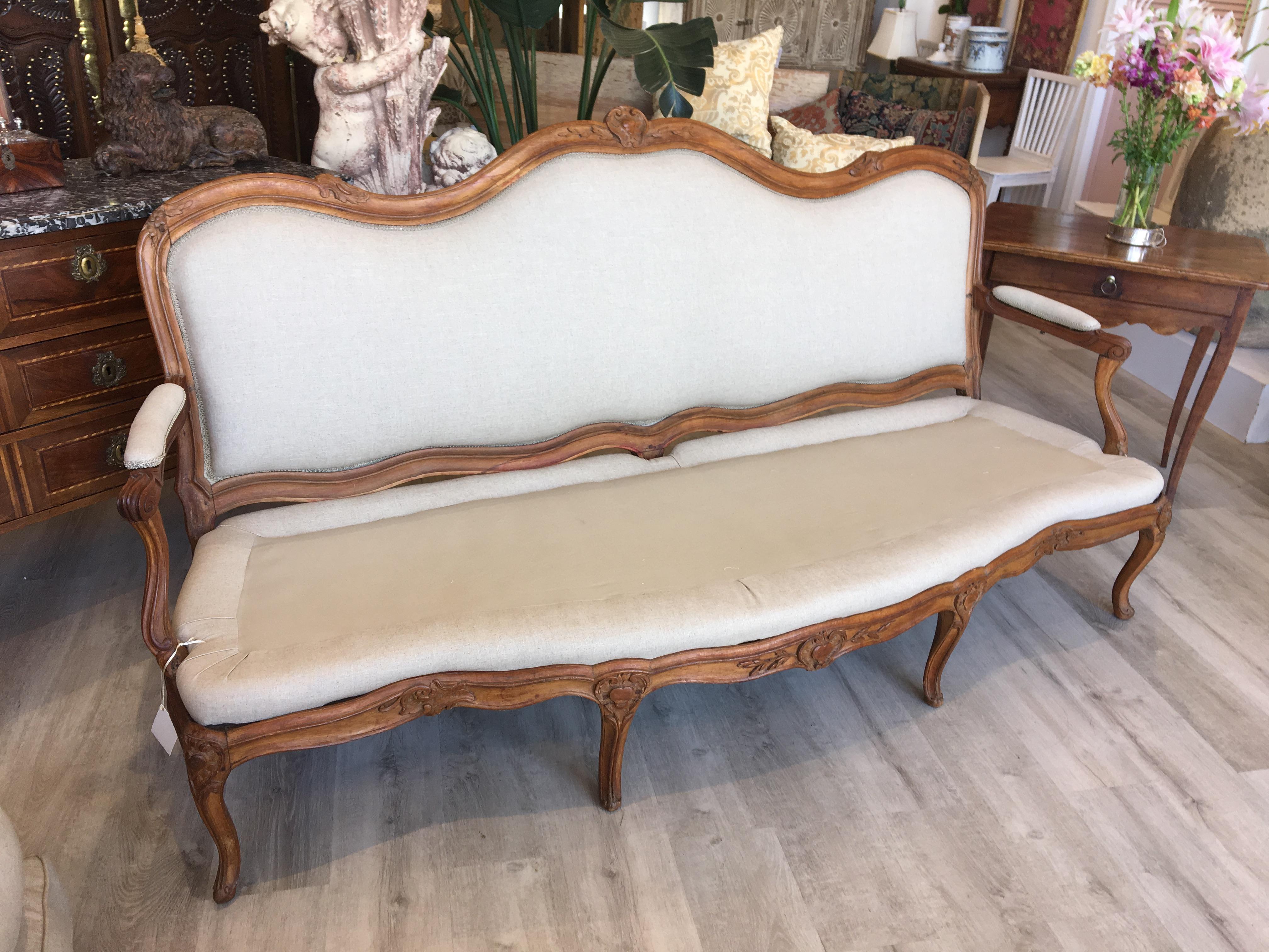 An important, signed Louis XV period canapé à chassis by Michel Gourdin. Made of beechwood, the padded back with a carved serpentine back, part padded arms on scroll terminals and a serpentine seat a carved seat rail and channeled cabriole legs with