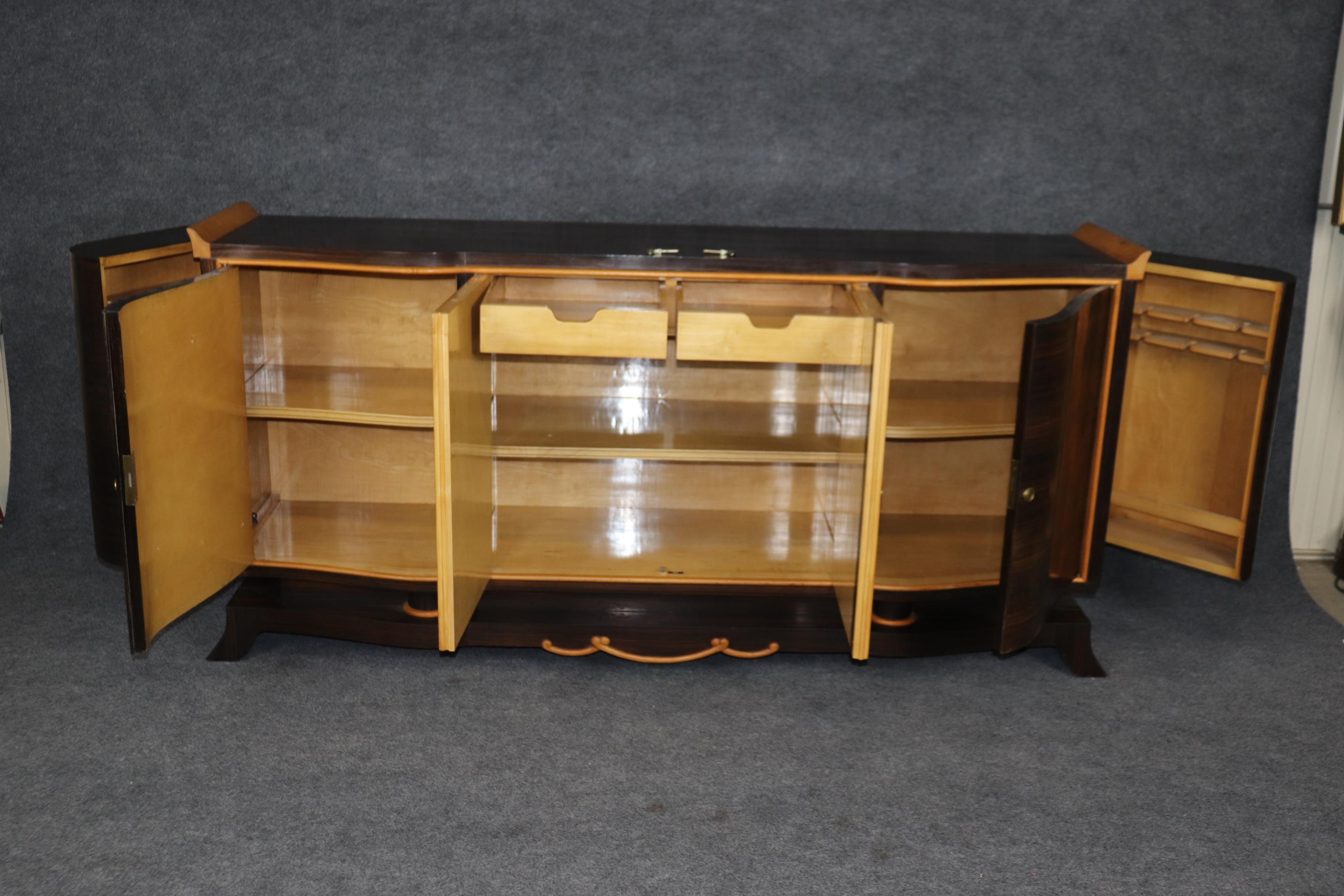 This is a superb French Art Deco sideboard with bar cabinet side doors and gorgeous sumptuous Macassar ebony wood on the outside of the case and incredible satinwood and high polished interior. The doors each have small bar cabinets built-in for