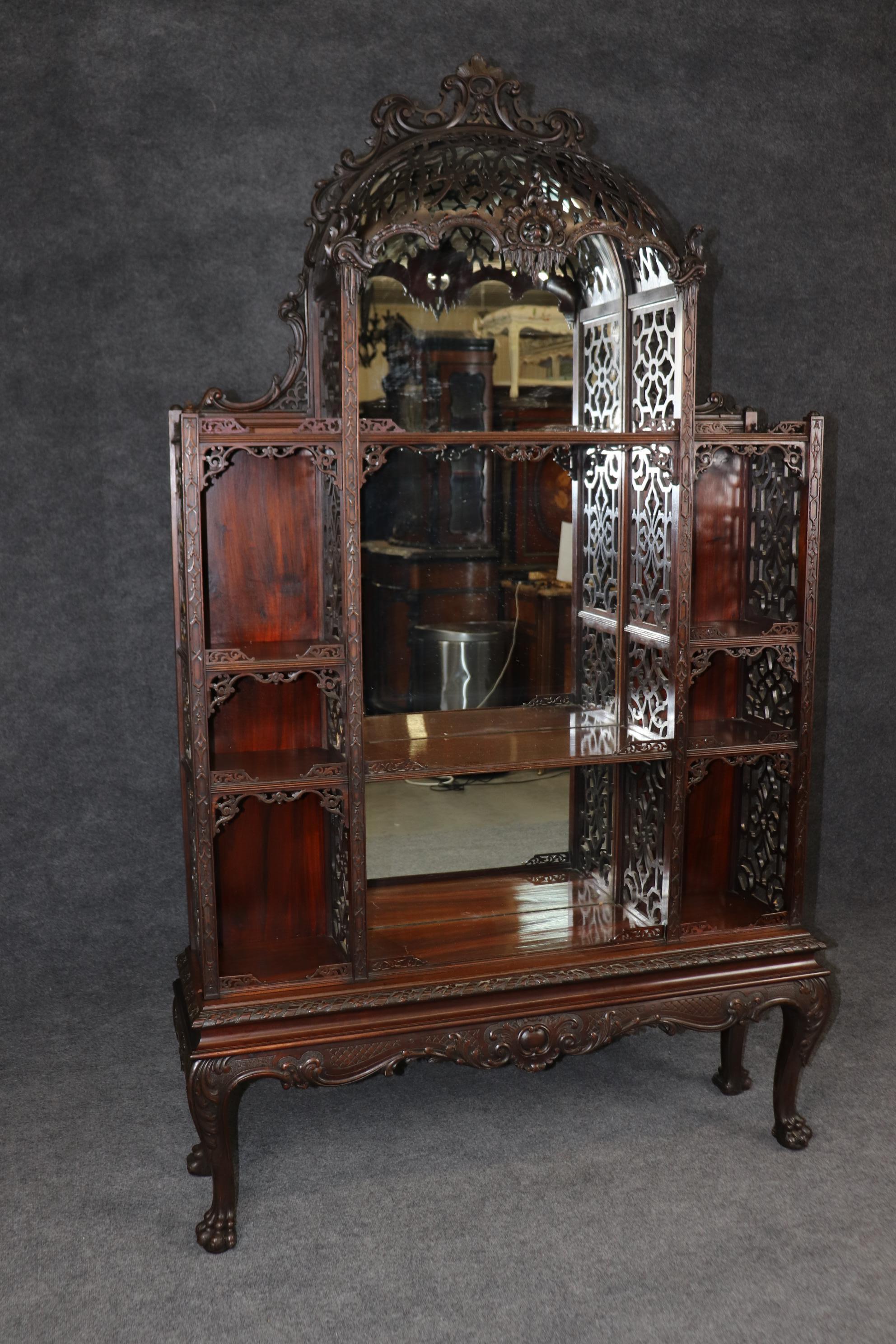 Si tratta di una spettacolare etagere a baldacchino inglese. L'etagere è progettata in stile Chippendale cinese e presenta un piano o un baldacchino in mogano laminato intagliato e una cornice in mogano scuro intagliato con pannelli a specchio sul