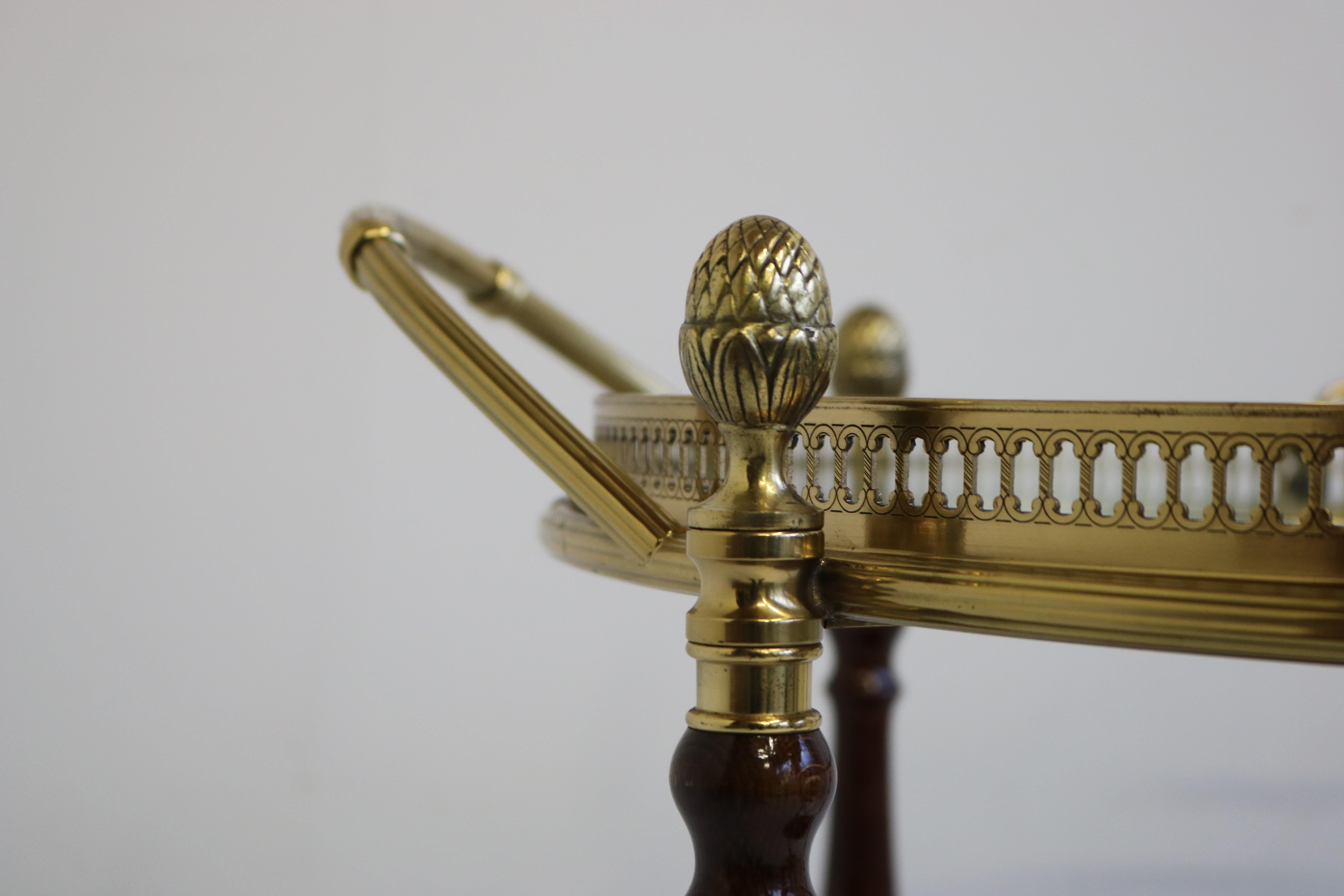 Raro carrello da bar / carrello di servizio rotondo francese Maison Jansen 1970, in mogano ottone. 
Incredibile ed elegante modello rotondo con vassoio rimovibile sulla parte superiore e lussuosi accenti in legno di mogano. 
4 Grandi punte di