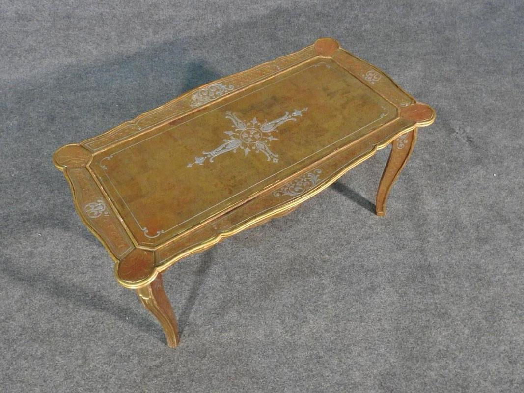This is a spectacular and very rare Maison Jansen coffee table that is made entirely of glass that's been done in gold and silver leaf under glass in églomisé. There are hairline cracks as shown, circa 1950. The table measures 17 1/4
