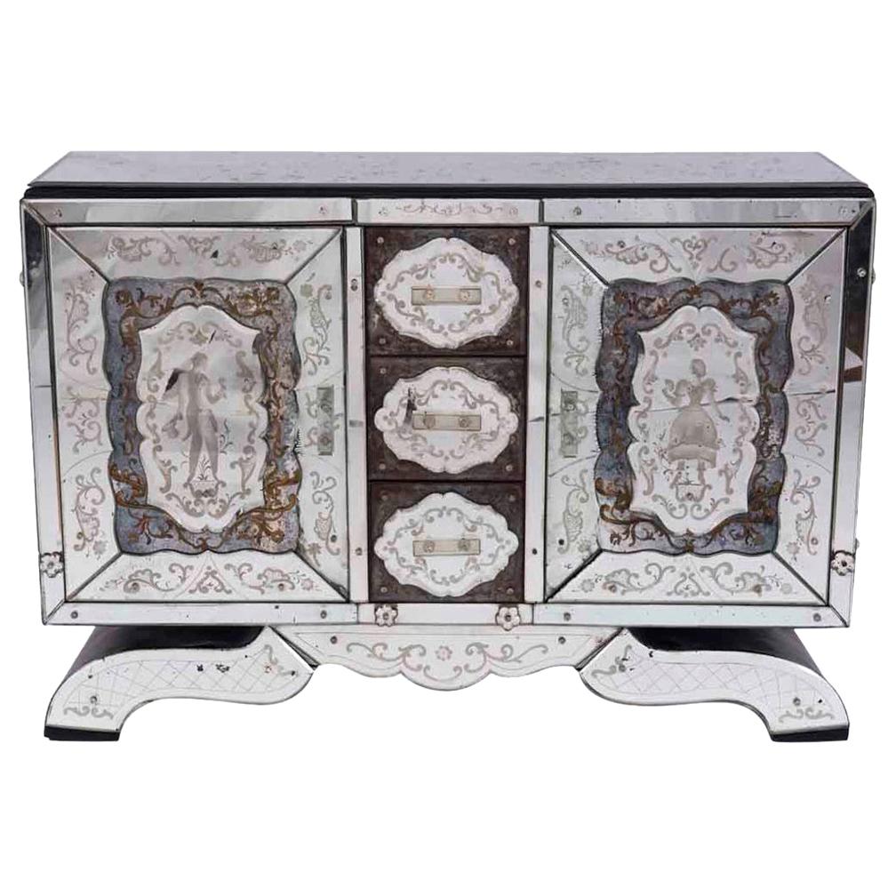 A rare Maison Jansen verse églomisé server or buffet having an ebonized top over three Venetian etched glass decorated drawers, circa 1940. The drawers are flanked by two paneled doors with figural decoration, all raised on a serpentine shaped base.