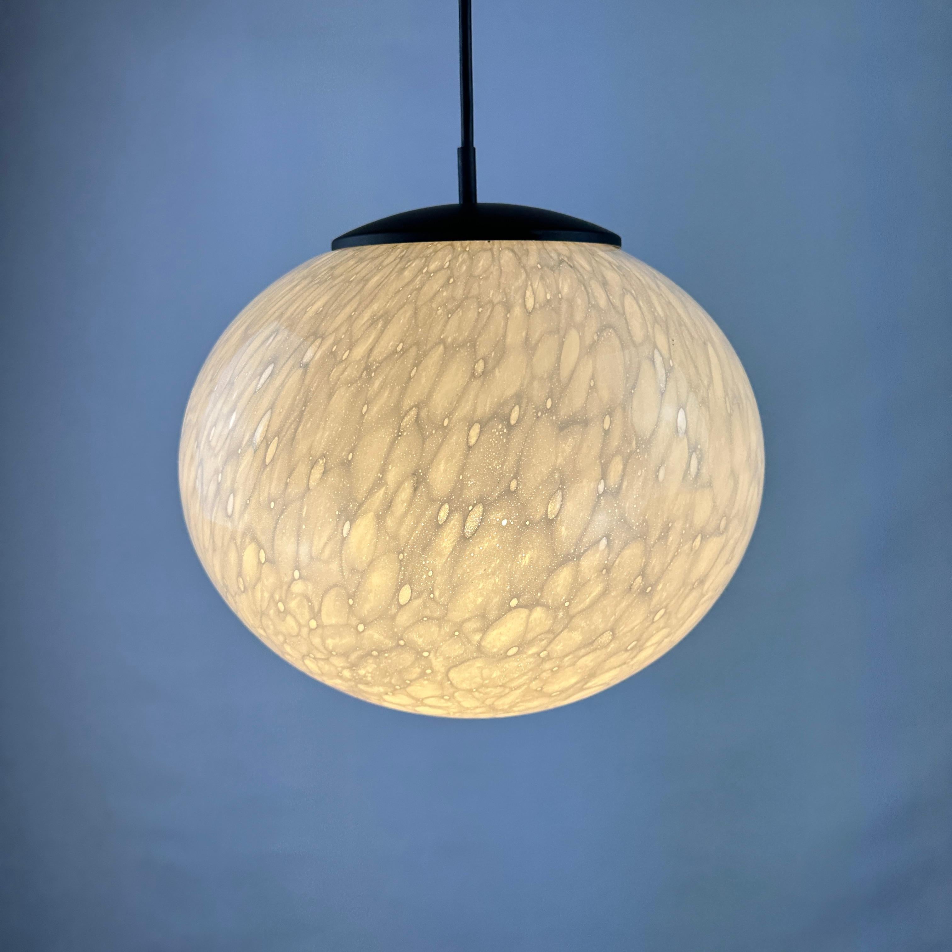 This white globe glass pendant light is made by Peill and Putzler and is produced around 1970. It has a marbled pattern which is made due the glass blowing process which makes this a unique piece. 

This is a pretty rare piece that doesn't show up