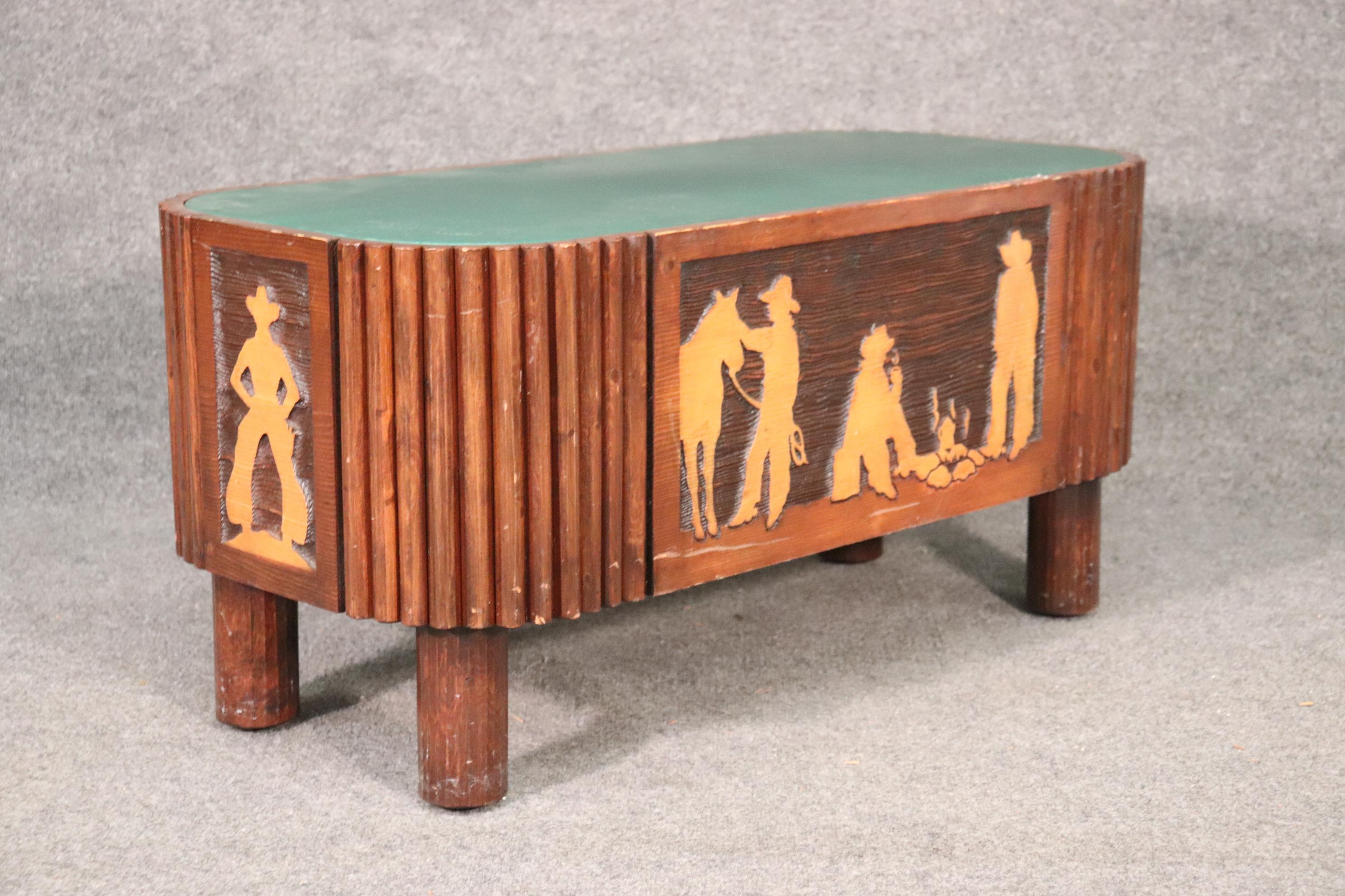 This is a wonderful carved coffee table with three cowboys at a fire with their horse. The table is still being made. The table is in very good condition. The table measures 38 wide x 18 inches tall x 18 inches deep.