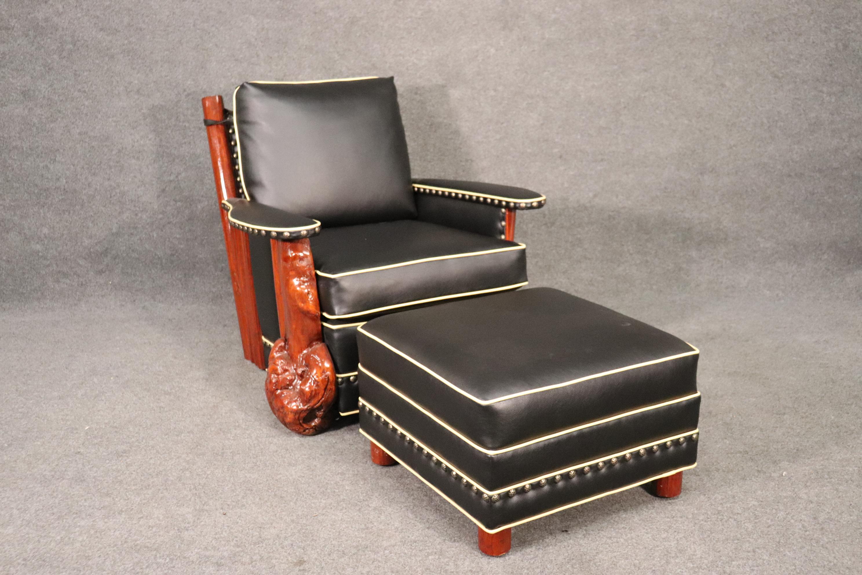 Marc Taggart Made this chair and matching ottoman. They are still making these chairs today. The chair is made of douglas fir and has genuine top-grain black leather with western style brass nailhead trim and a beautiful design. It's like a mix