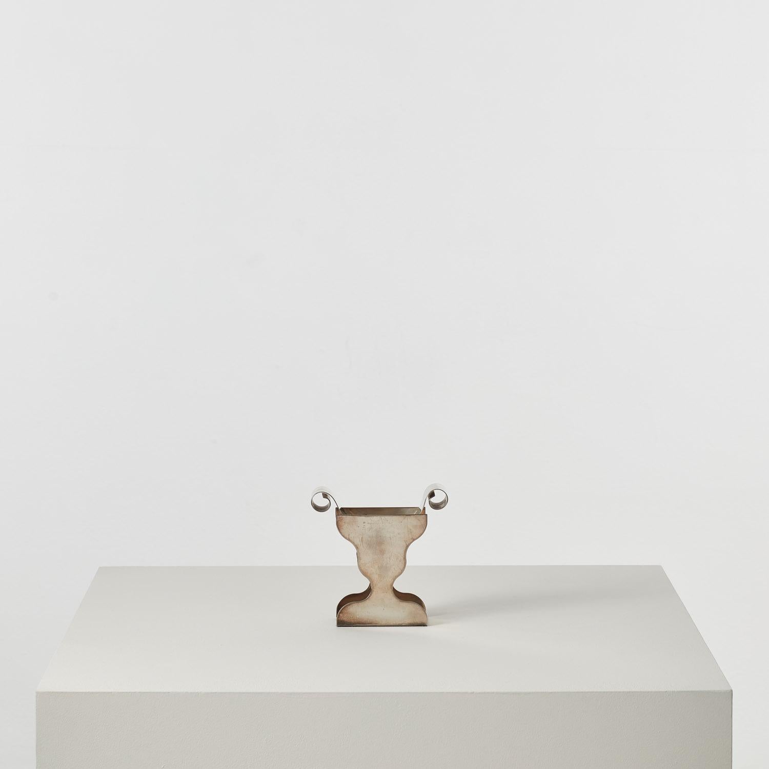 A rare and distinctive modernist vessel designed by lesser-known Memphis co-founder Marco Zanini. It bears Memphis hallmarks in its bold subversion of classical forms but eschews the movement’s saturated primary shades and pastels. 

Zanini (b.1954)