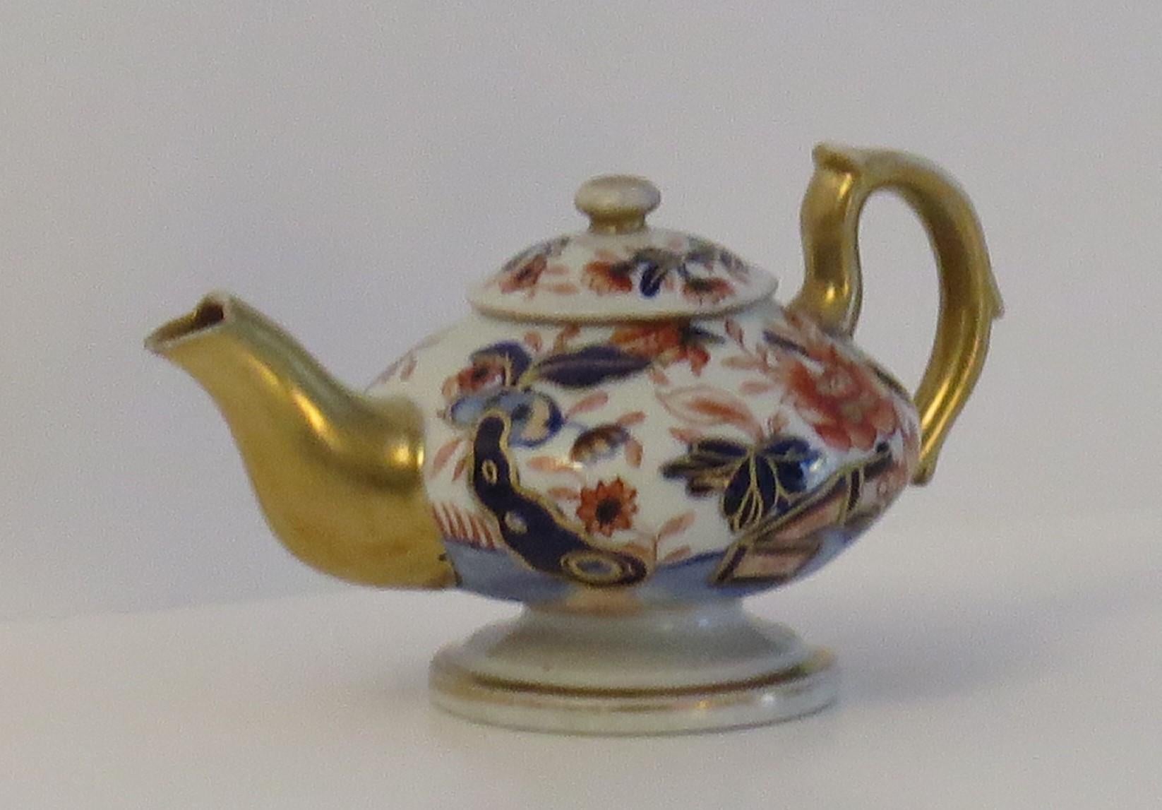 This is a rare Mason's ironstone miniature Teapot in the bold Fence Japan gilded pattern, which we date to circa 1820.

Miniature or toy items of Masons ironstone are hard to find today.

This piece is well potted as a Teapot with a high loop