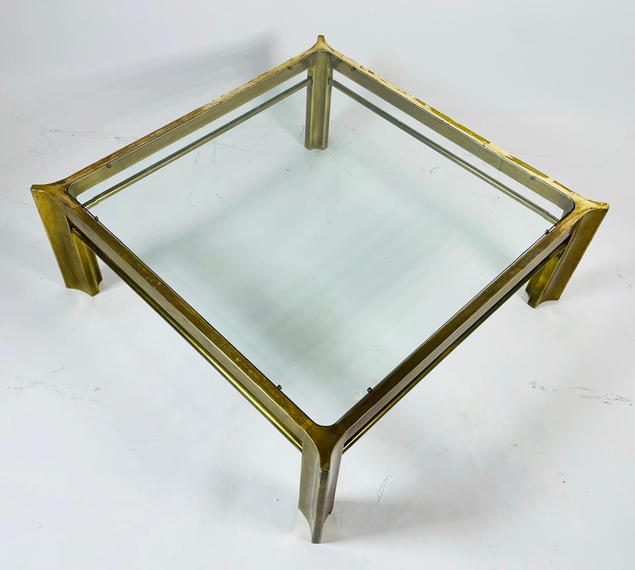 Rare coffee table by Mastercraft with glass bevel edge top on brass frame. The four legs are based off their 