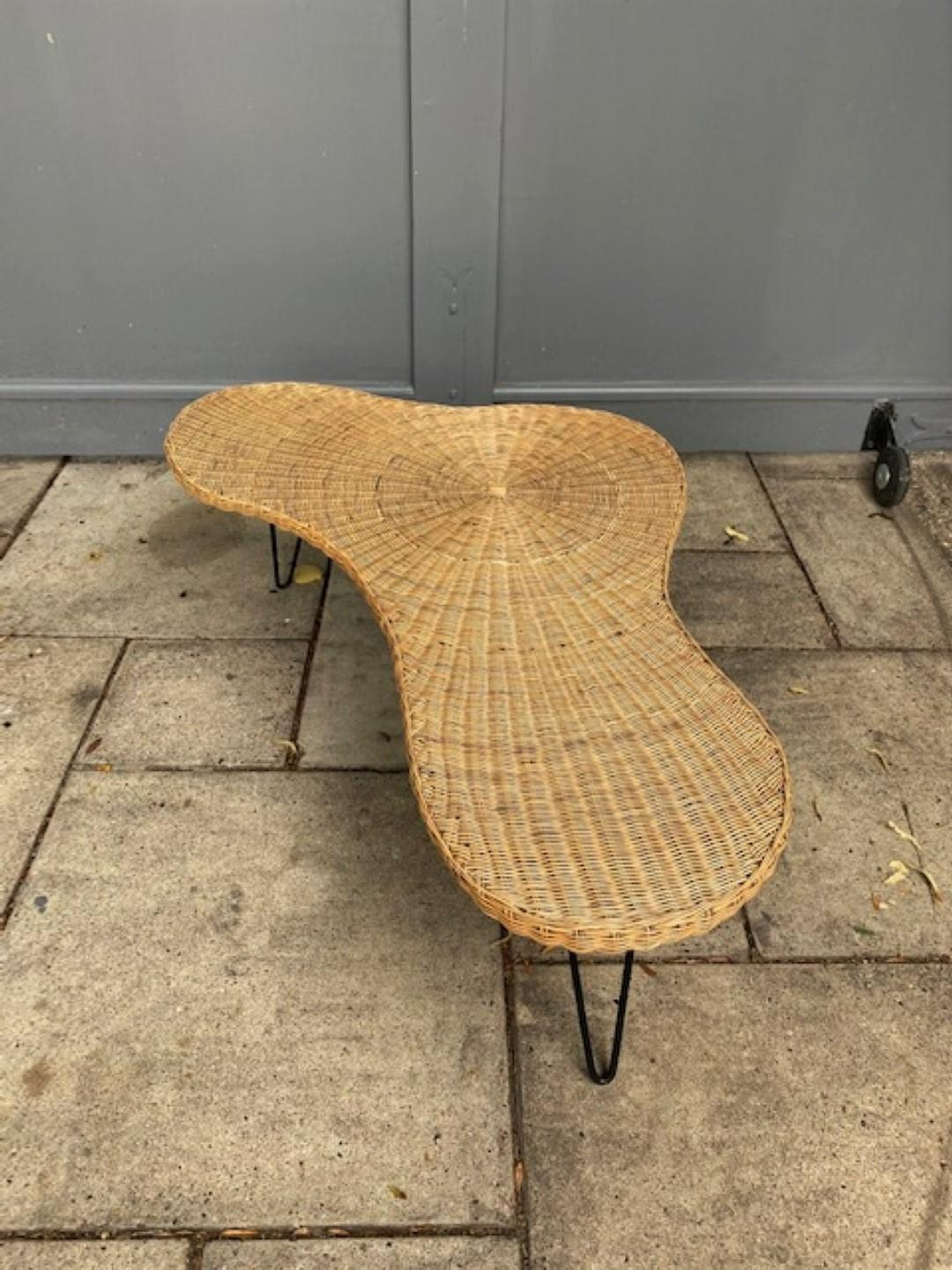 Mid Century Biomorphic Amoeba Wicker & Iron cocktail /coffee table, France, 1950s

Rare Mid Century biomorphic organic shape wicker and iron cocktail / coffee table in rattan wicker over solid wood base and black iron hairpin legs. This piece is in
