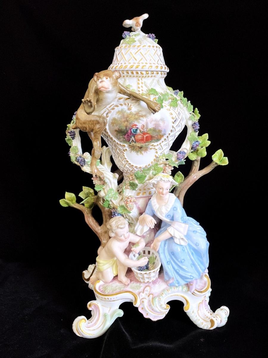 Unique Meissen potpourri vase designed by Johann Friedrich Eberlein.

Perforated baluster shaped vase with additional figurines and some branches with grapes and leaves. On top a monkey reaching out his hand.

Hard to find item with absolutely