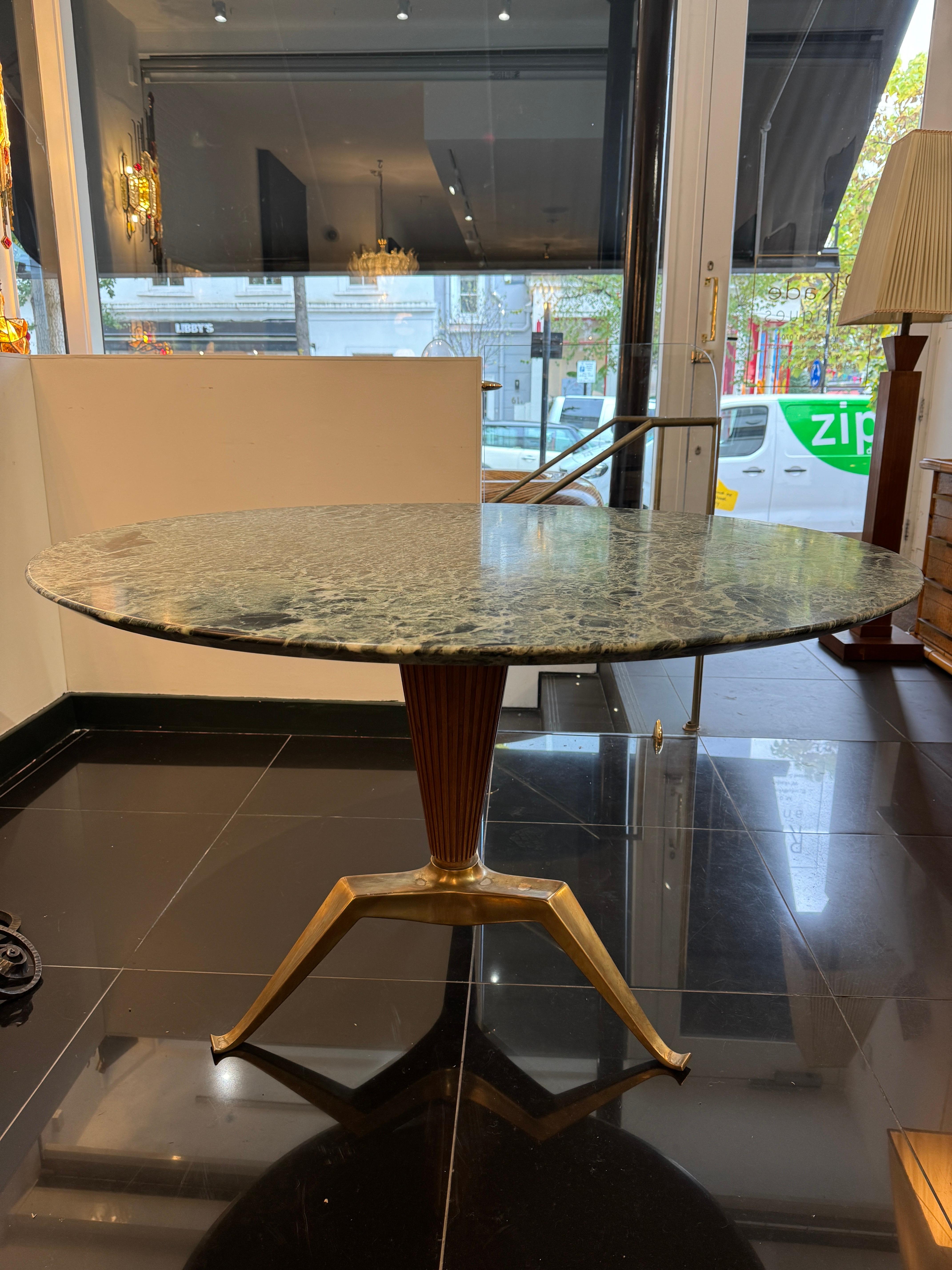 Melchiore Bega (1898-1976 ) . Green marble top circular dining table supported by fluted walnut wood base to the centre and standing on three sculptural legs in heavy solid brass. A truly beautiful piece in outstanding condition. 


