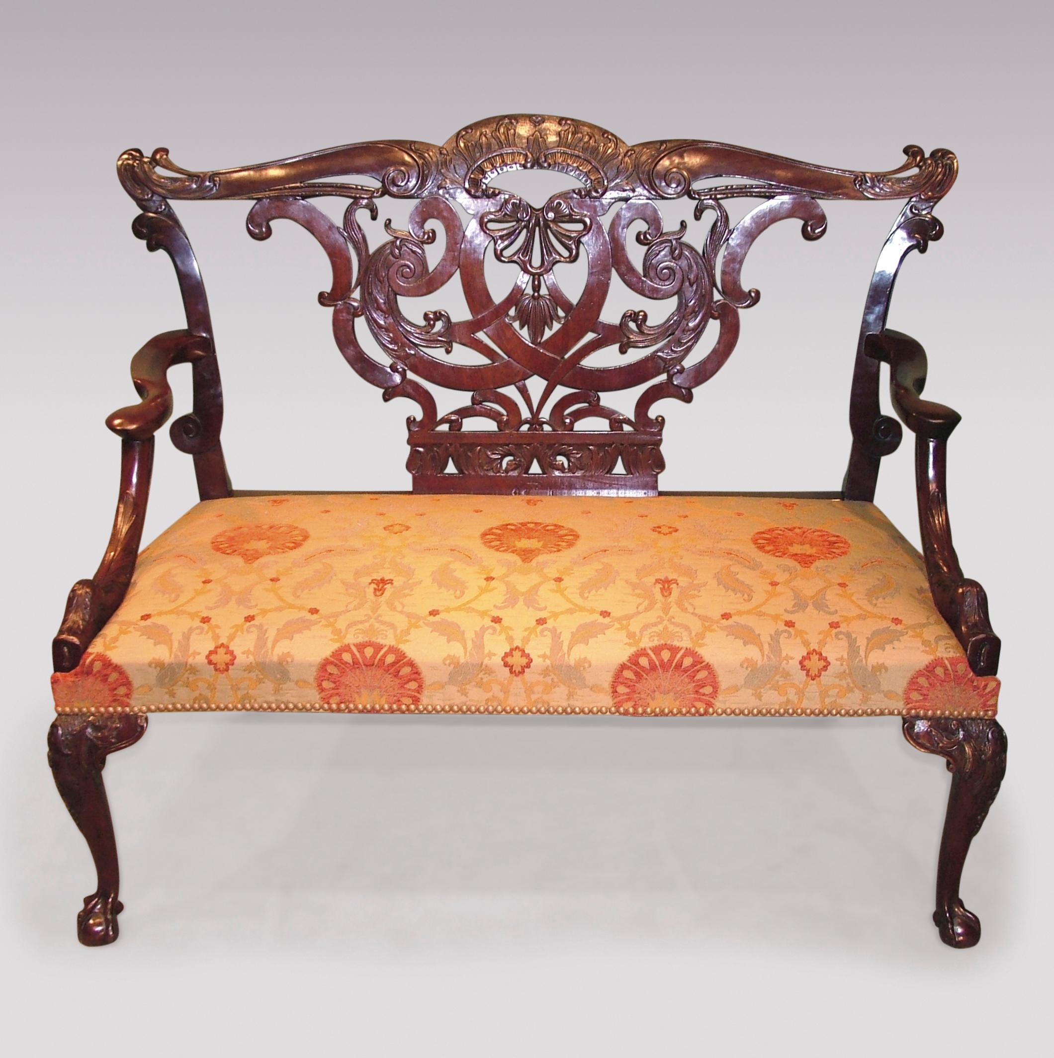 A rare mid-18th century Chippendale period mahogany two-seat settee having pierced acanthus carved arched top rail and central splat carved with 'C' scrolls and foliage above shaped outswept arms with acanthus carved supports, raised on cabriole