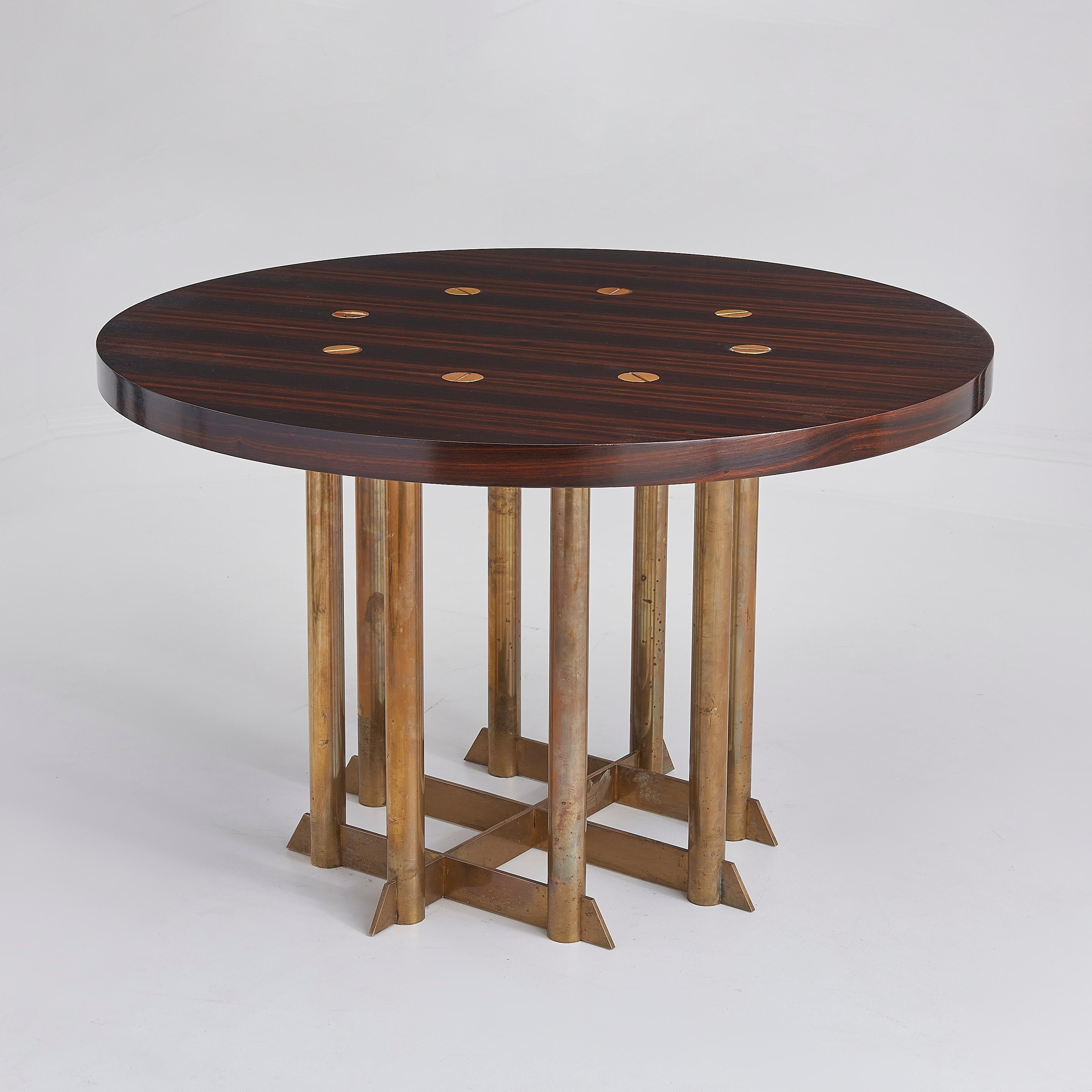 Cette table de salle à manger exquise du milieu du XXe siècle est un exemple rare de design moderniste brésilien magistral, fabriqué à partir d'un riche bois de jacaranda. 

Avec son plateau rond et ses détails circulaires en laiton incrustés, cette