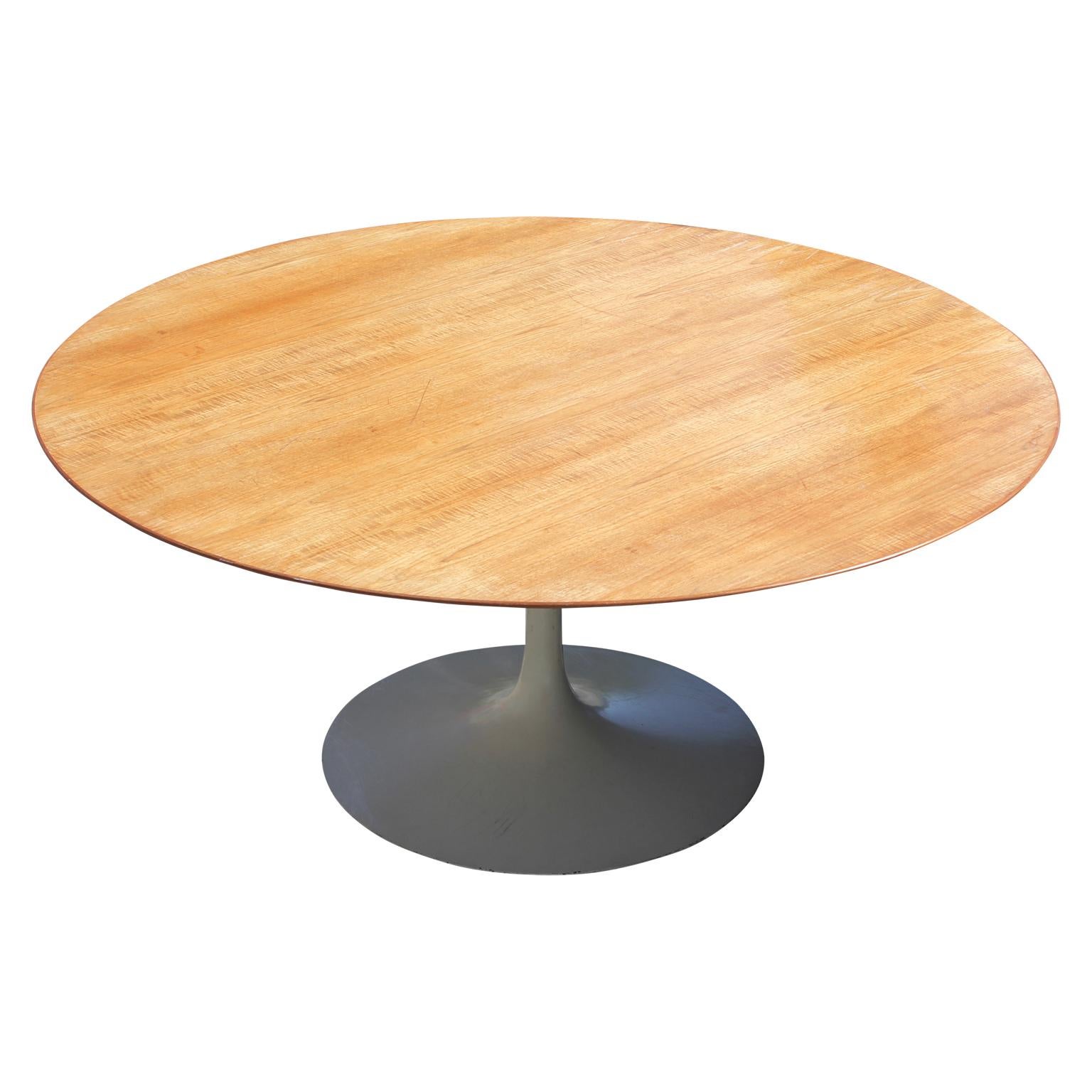 Rare midcentury round tulip table by Knoll and Saarinen. The wooden tabletop has a 68 inch diameter and seats four or five people. The base of the table is made from painted cast aluminum. The tabletop is in good vintage condition, and the pedestal