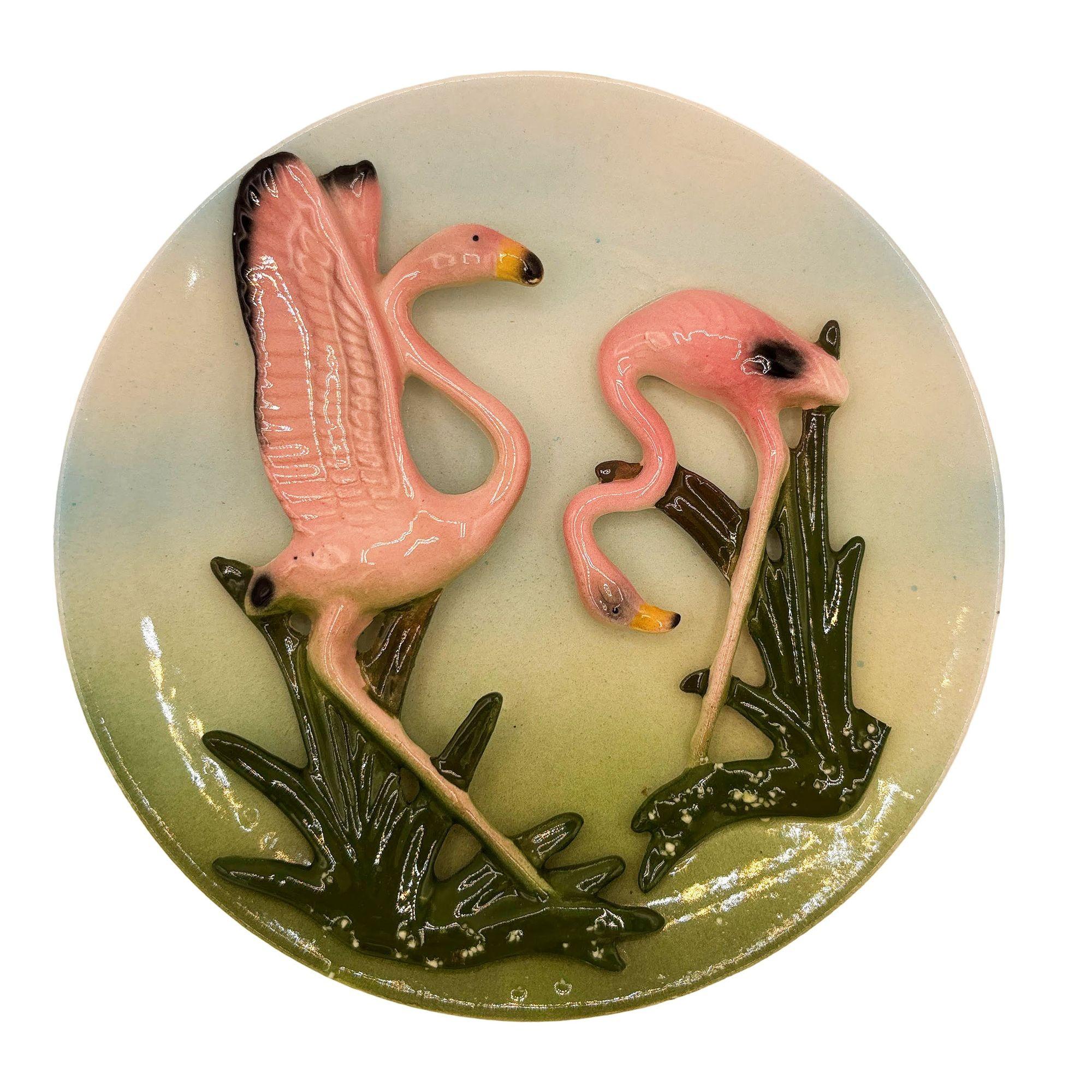 Mid-Century rosa und grün 3d skulpturale Keramik California Keramik Flamingo Thema Blume Wandplatte. Der Wandteller zeigt ein wunderschön detailliertes Paar rosa Flamingos in einem grasbewachsenen Feld. Die glänzende Oberfläche hebt die kräftigen