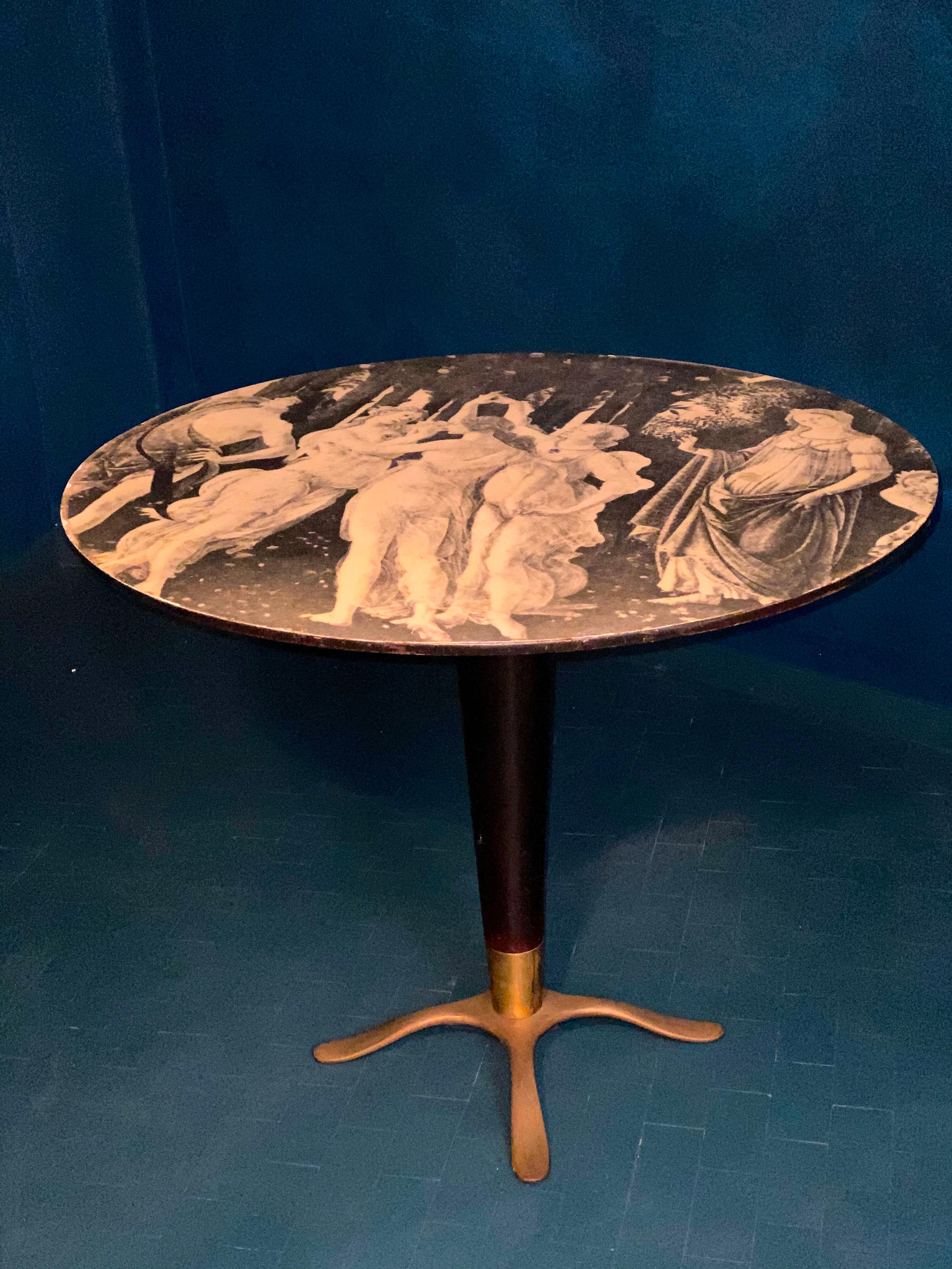 Elegant Italian center table or occasional table with brass tripod base.
The tabletop decoration with Boticelli lithographic print on lacquered wood base and glass top.
 Very good vintage condition 