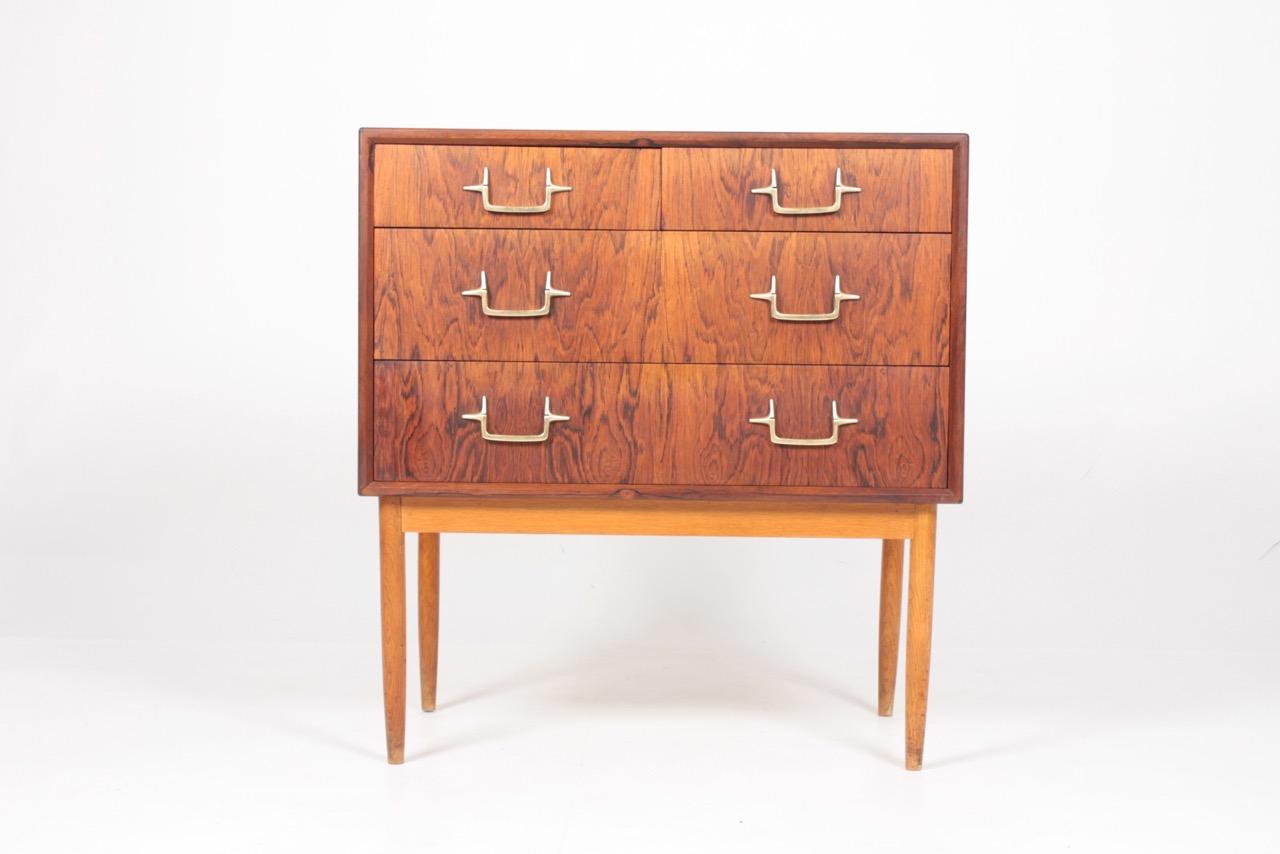 Great looking chest of drawers in rosewood with frame in oak and handles of brass. Designed and made by Mogens Lysell. Great original condition.