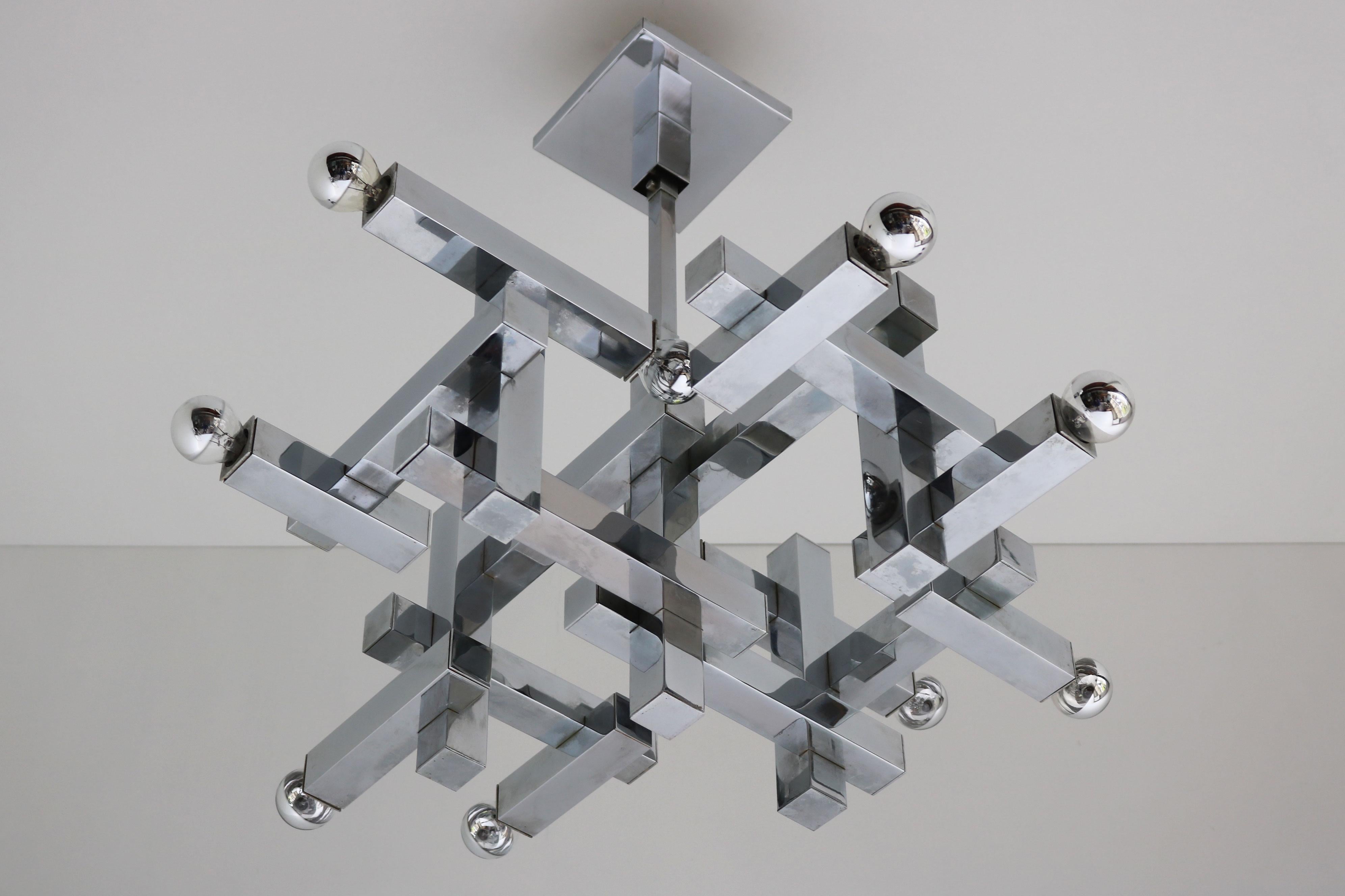 Eleganza senza tempo per questo lampadario vintage cromato Model No: Metric, progettato dal leggendario Gaetano Sciolari nel 1960. Questo splendido capolavoro della metà del secolo scorso è caratterizzato da un'elegante finitura cromata e da dieci