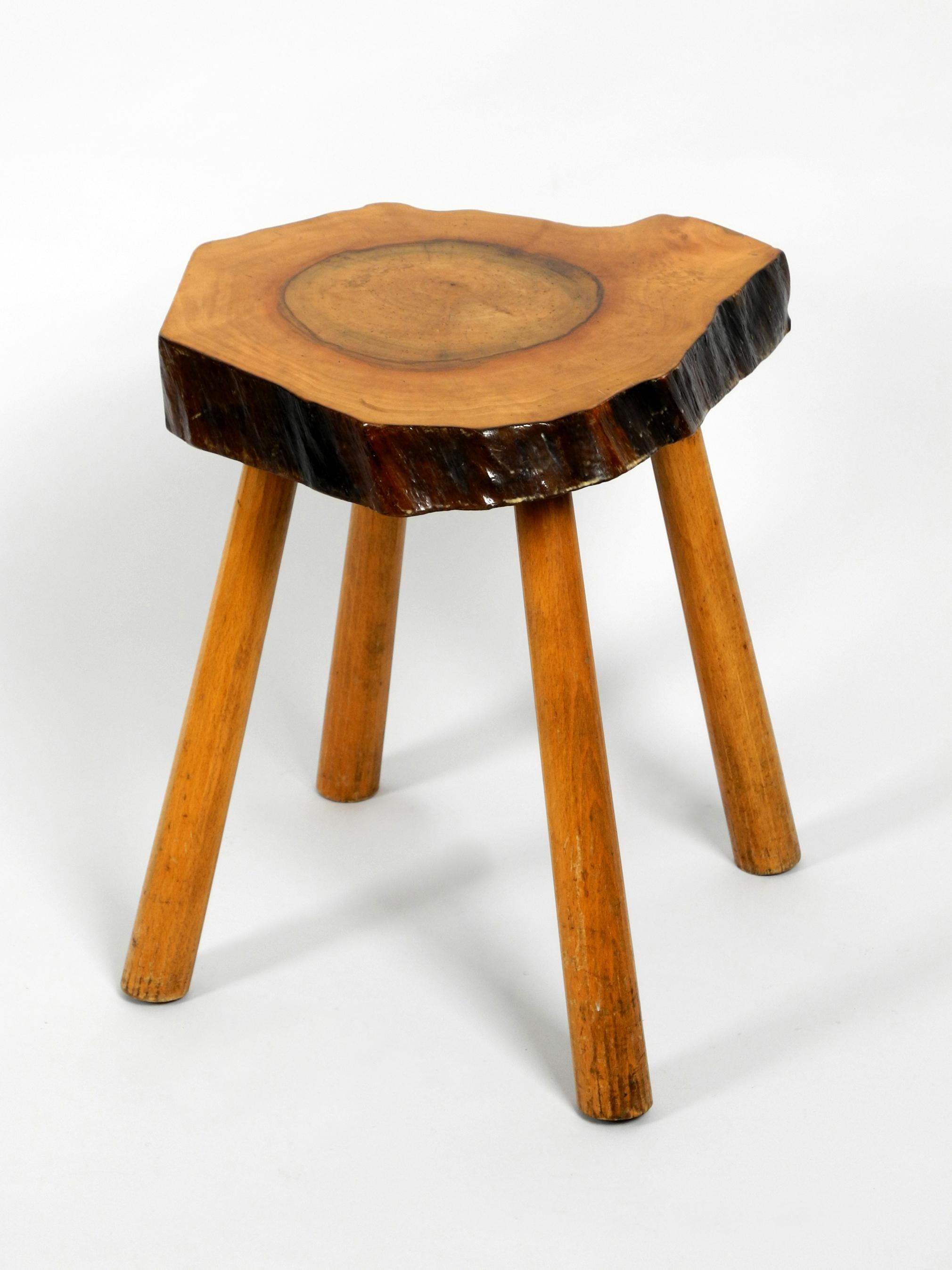 Beautiful solid wood four-legged side table made of a tree slice with bark. 
Treated just with clear varnish.
Very nice vintage condition with no damages. Fantastic patina.
Legs made of thick solid wood, not shaky.
Very robust, can also be used