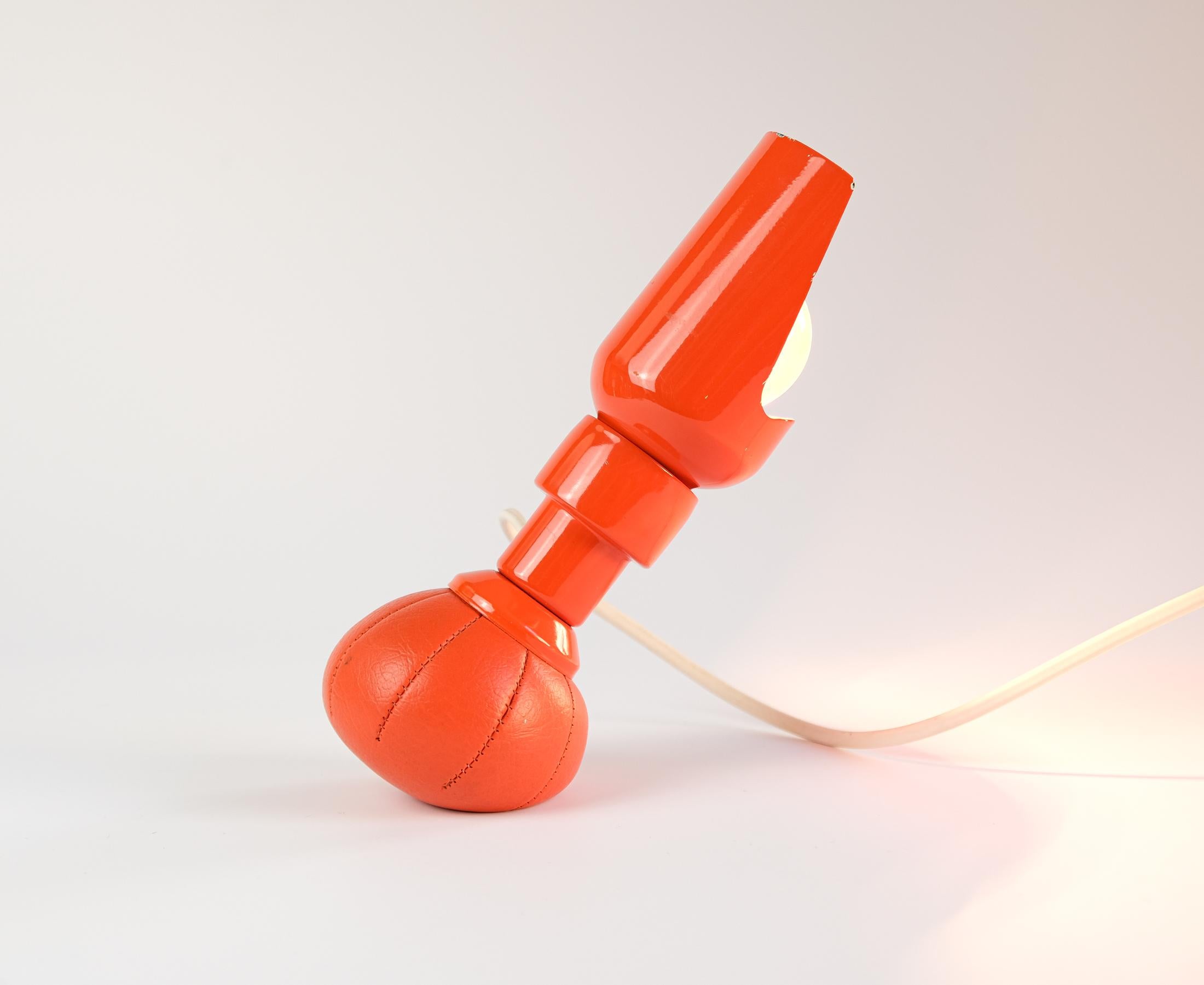 Se vende una icónica y rarísima lámpara de sobremesa naranja 600P de GINO SARFATTI, diseñada en 1966 y producida por Arteluce de Italia.

Gracias a su base de bolsa lastrada con plomo, la lámpara puede colocarse en cualquier ángulo y la pantalla