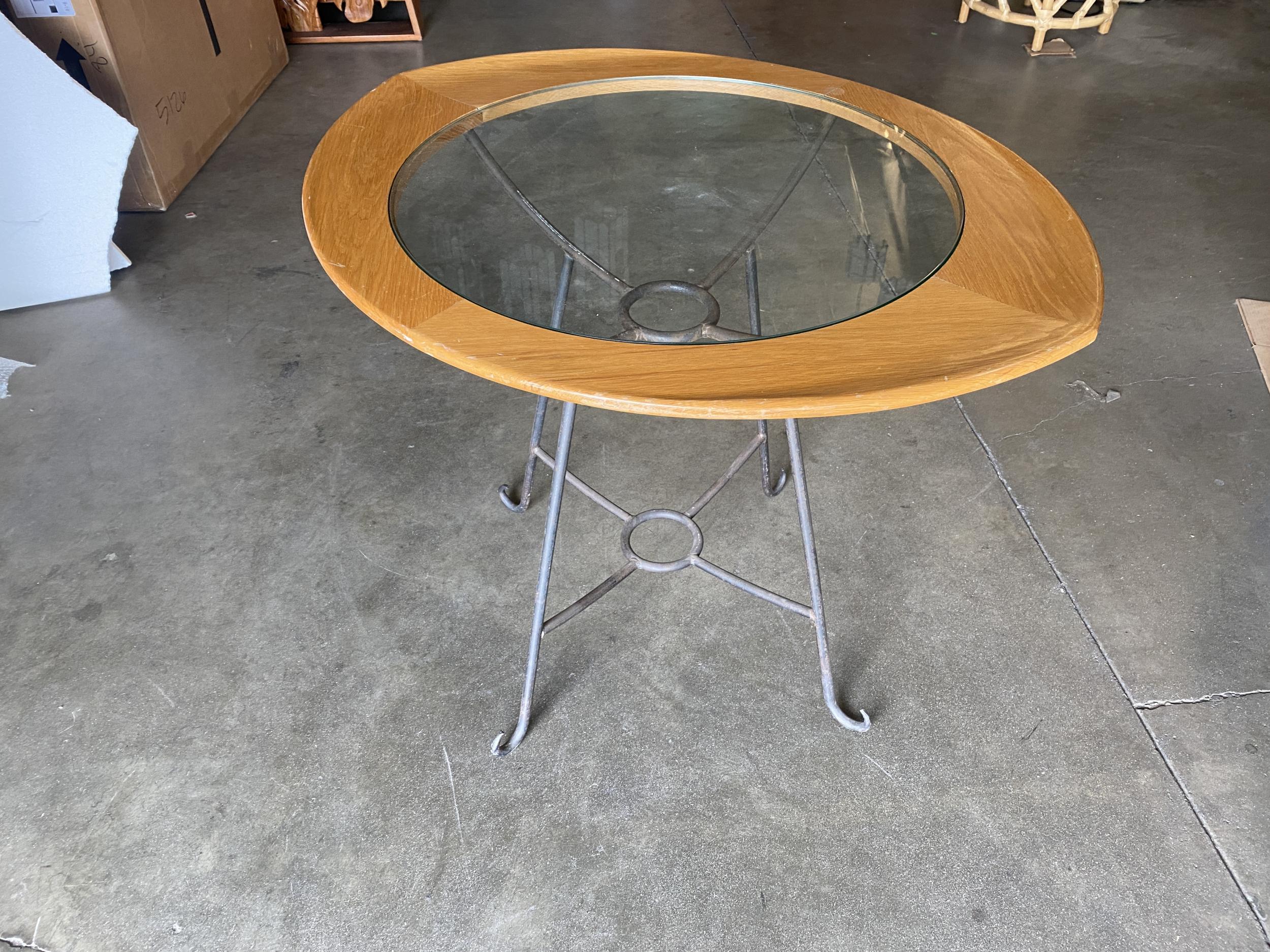 Rare mid-century glass center two person breakfast table with scrolling iron base.