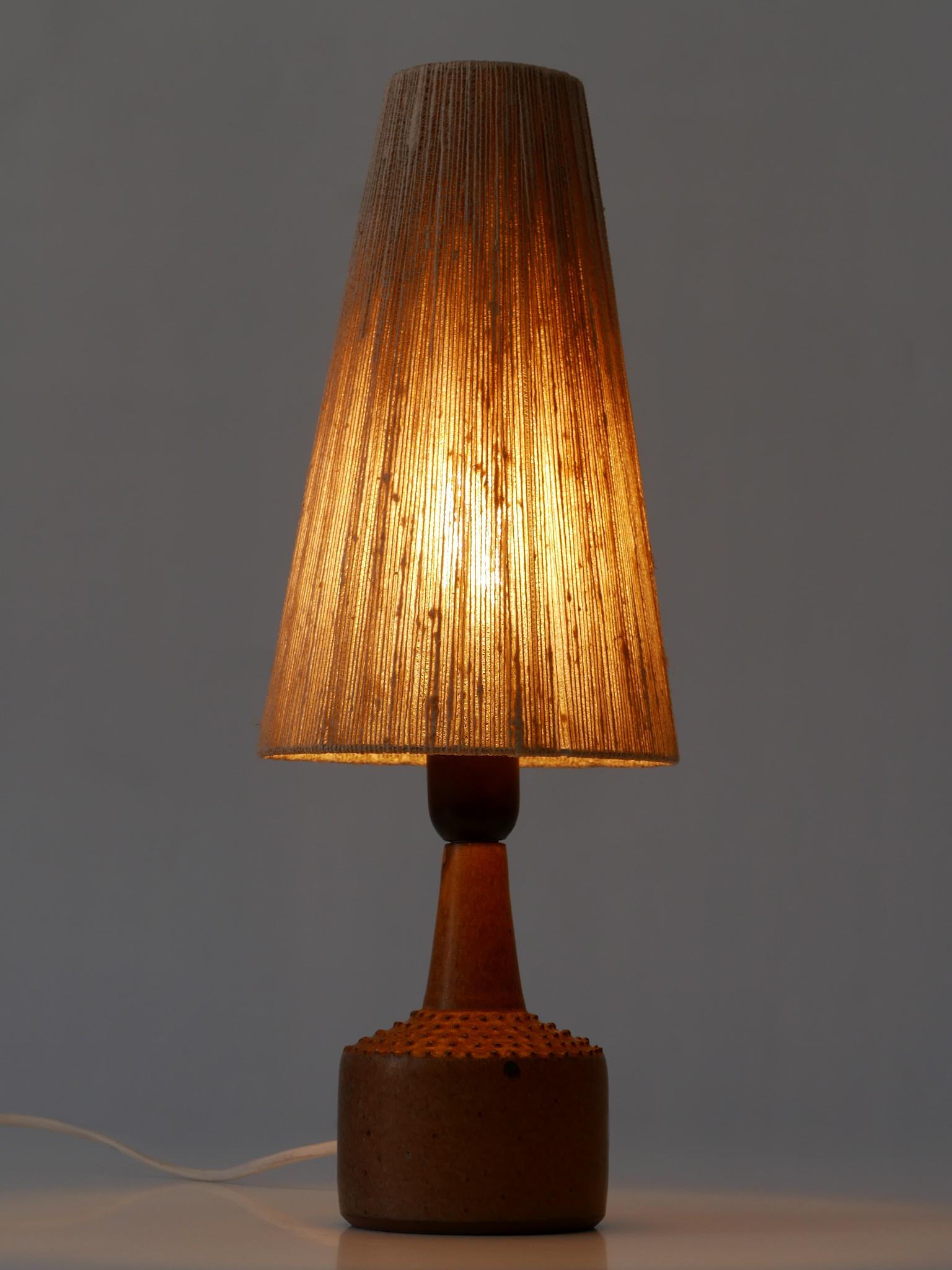 Rare and elegant Mid-Century Modern table lamp with original linen lamp shade. Designed by Rolf Palm for Mölle, Sweden, 1962. Signed and dated to the bottom of the base.

Executed in glazed stoneware and linen, the table lamp comes with 1 x E27 /