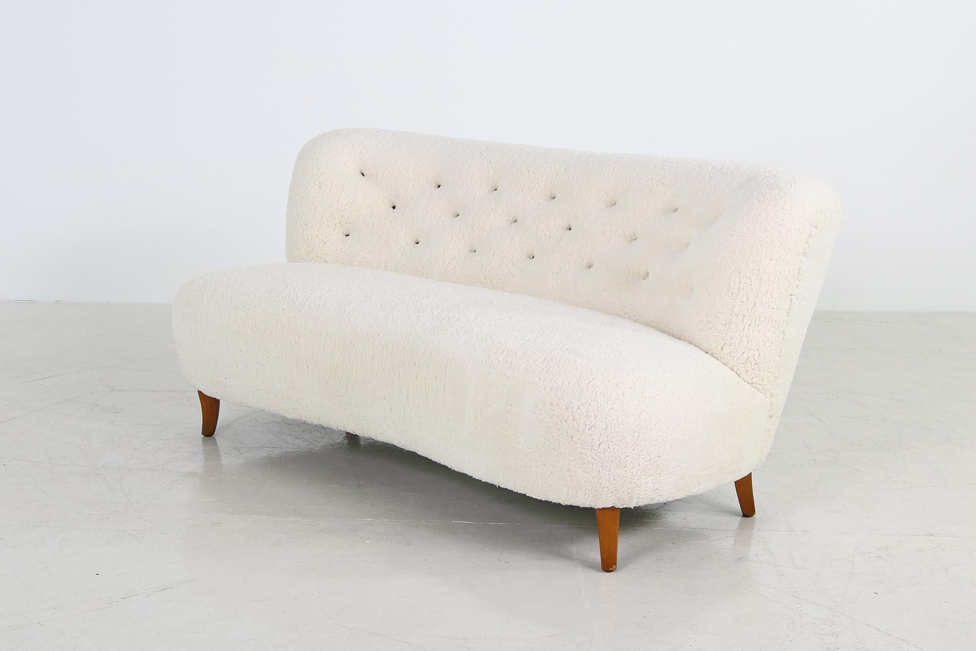 Beautiful 1950s lounge sofa, design attirb. to Gösta Jonsson, Jönköping Sweden, rare piece, stained and solid beechwood legs, new upholstery and covered with a super soft bright teddy faux fur fabric, very soft to the touch, tufted with beautiful