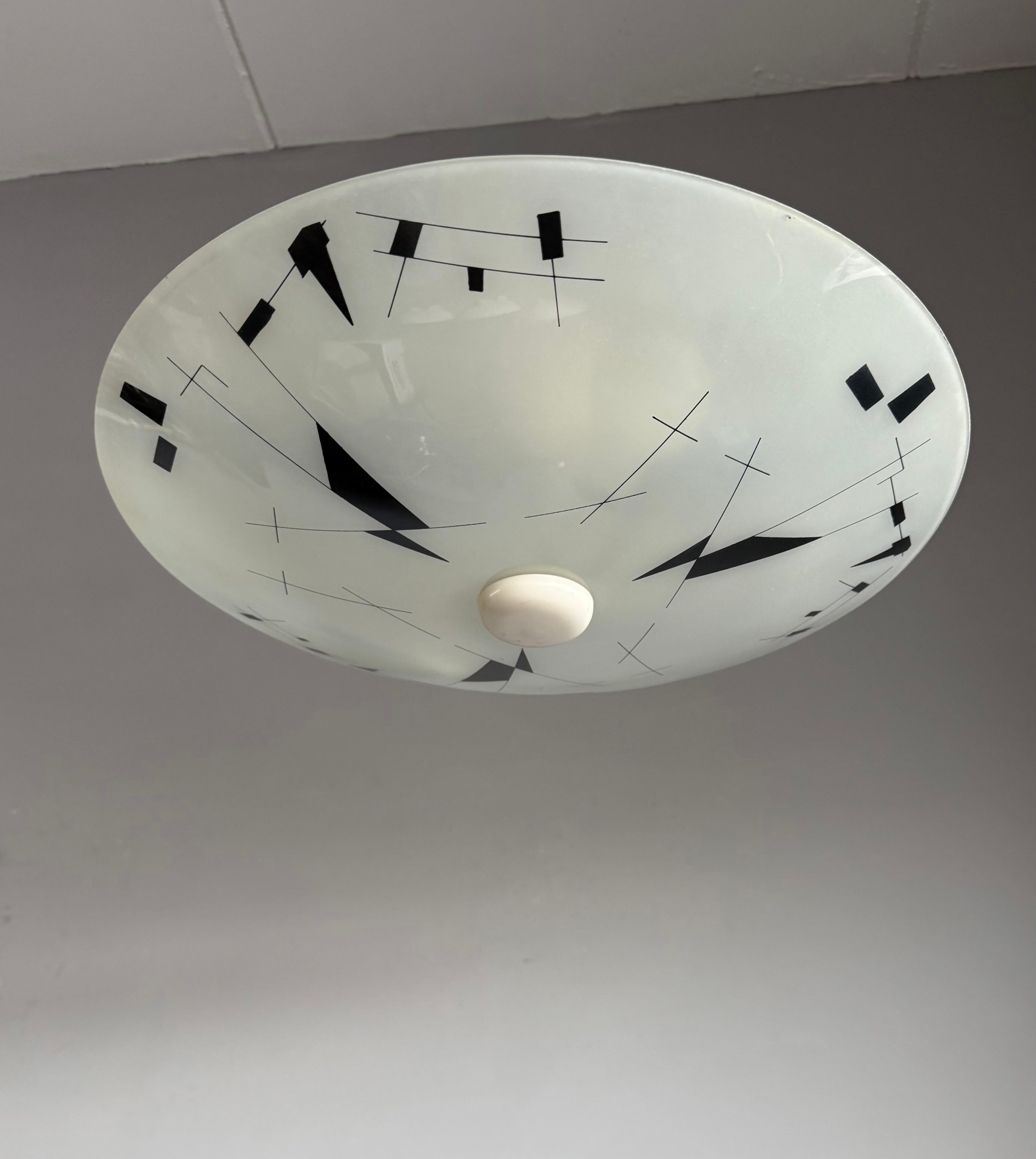 This Midcentury Modern, two lights fixture with Geometric Pattern is another one of our recent great finds. 

This striking Mid-Century Modern flush mount is a rare and elegant find, featuring a large, circular frosted glass shade adorned with a