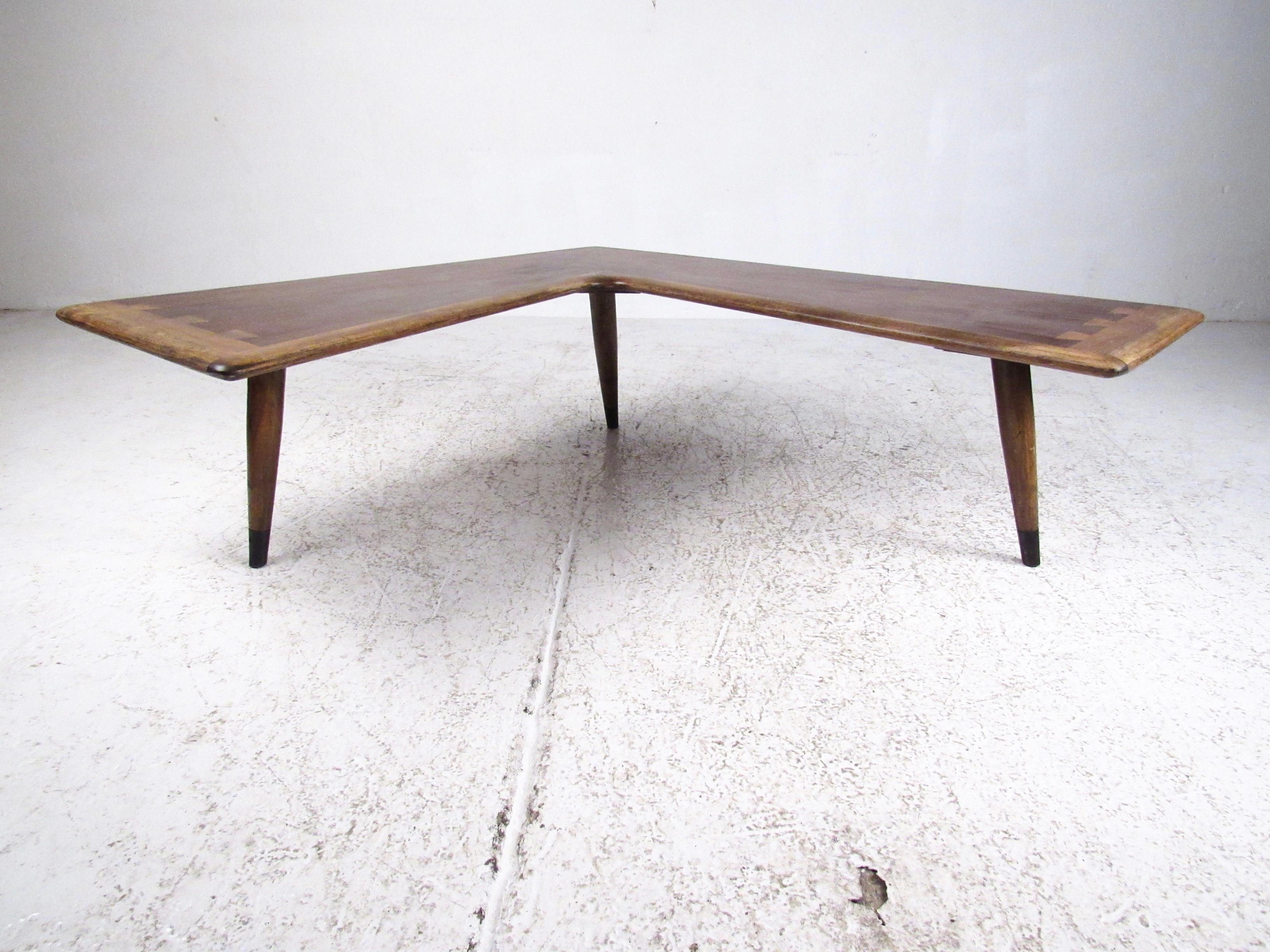 This striking Mid-Century Modern coffee table features iconic Lane joinery and impressive sculpted boomerang shape. The tapered hardwood legs and two tone wood finish make this a memorable centerpiece for home or business seating area. Perfect