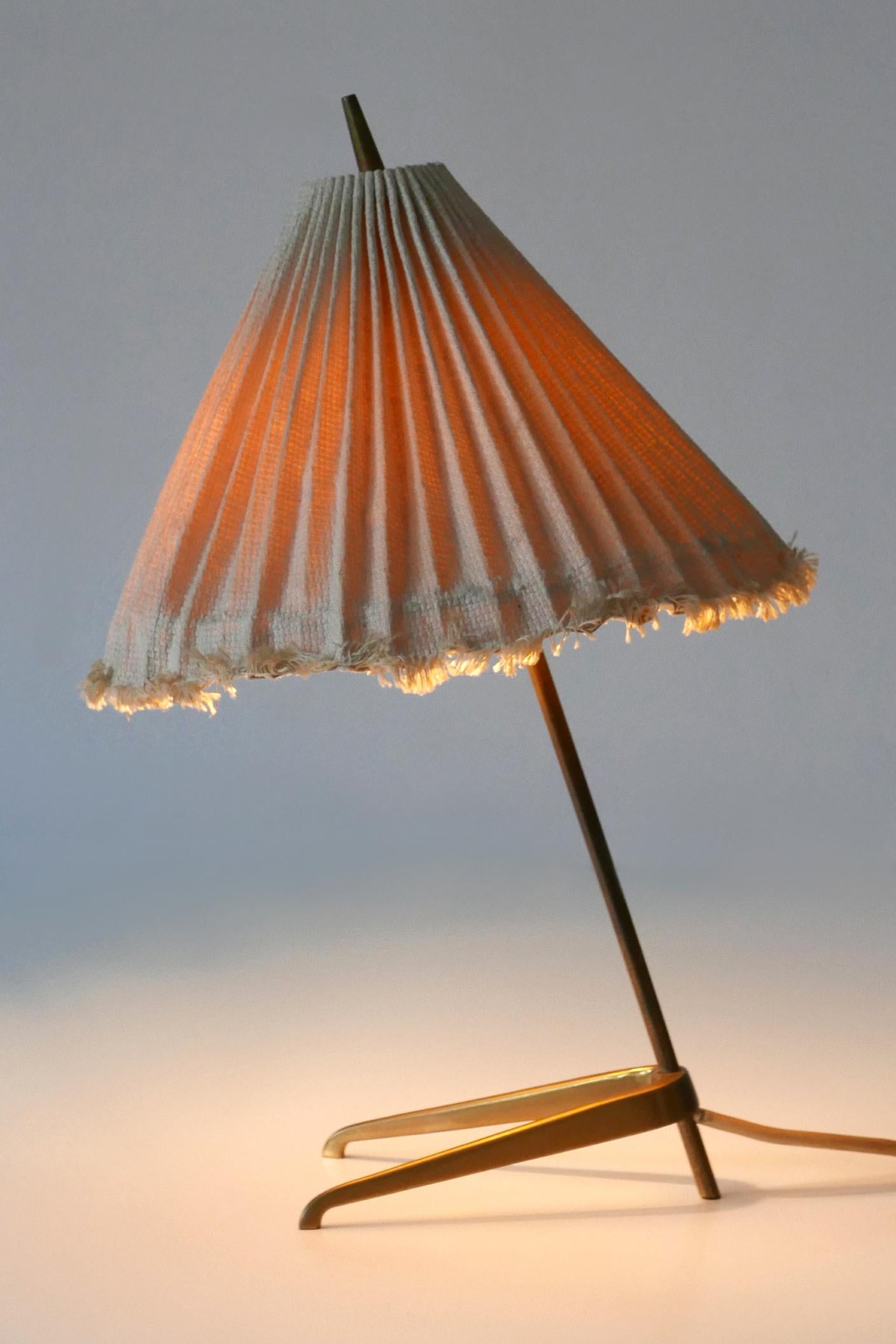 Extremely rare and elegant Mid-Century Modern table lamp. Designed & manufactured probably by J.T. Kalmar, Austria, 1950s.

Executed in brass and fabric, the table lamp comes with 1 x E14 / E12 Edison screw fit bulb holder, is wired, in working